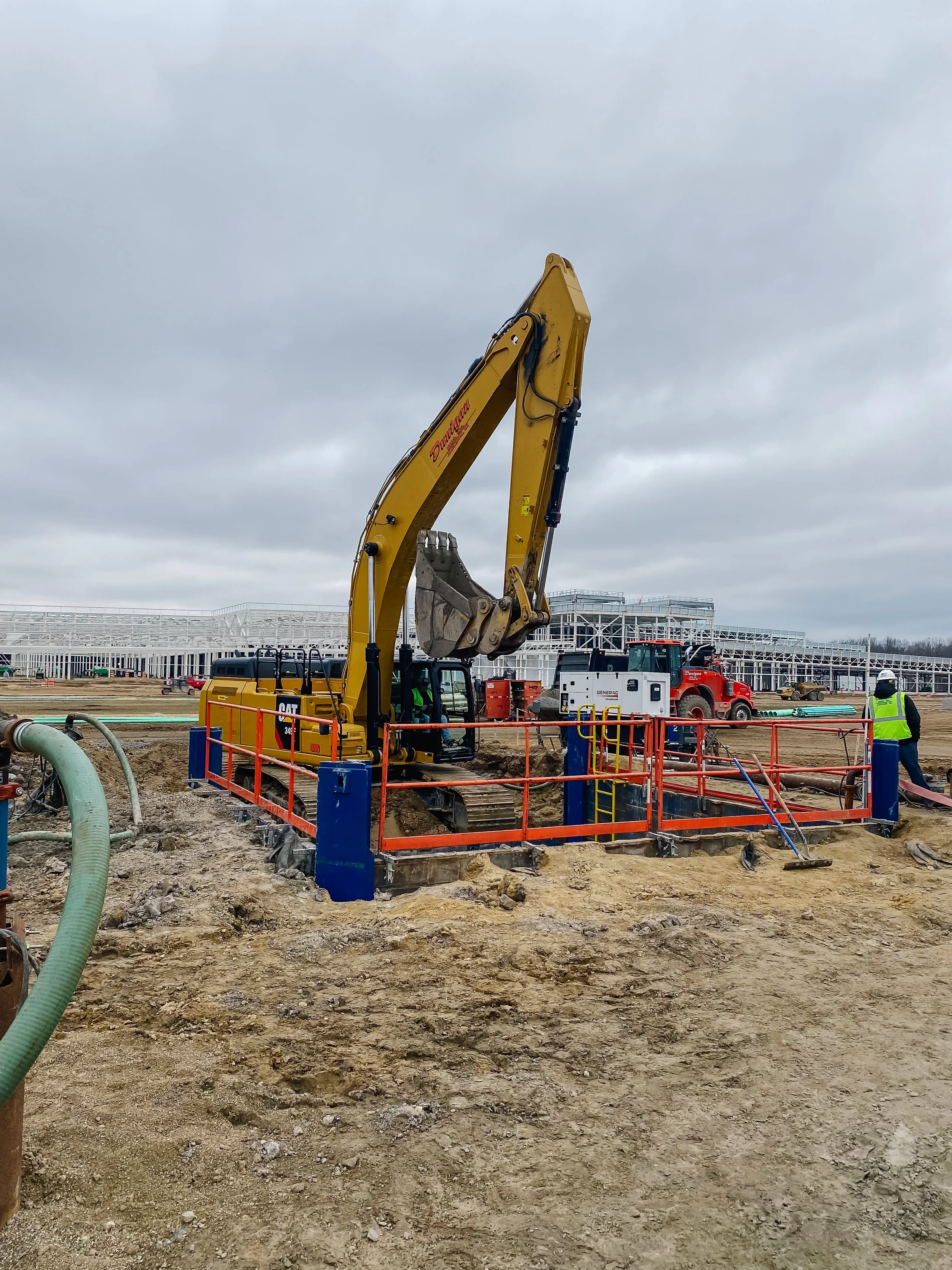 Dunigan Bros. excavator and crew members on an active underground utility project