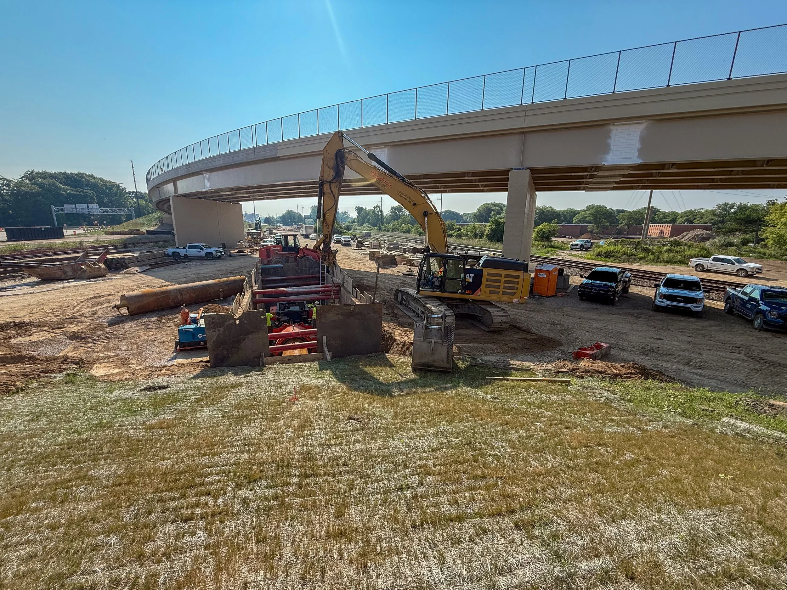 Dunigan Bros. construction site under a highway overpass with crew and equipment
