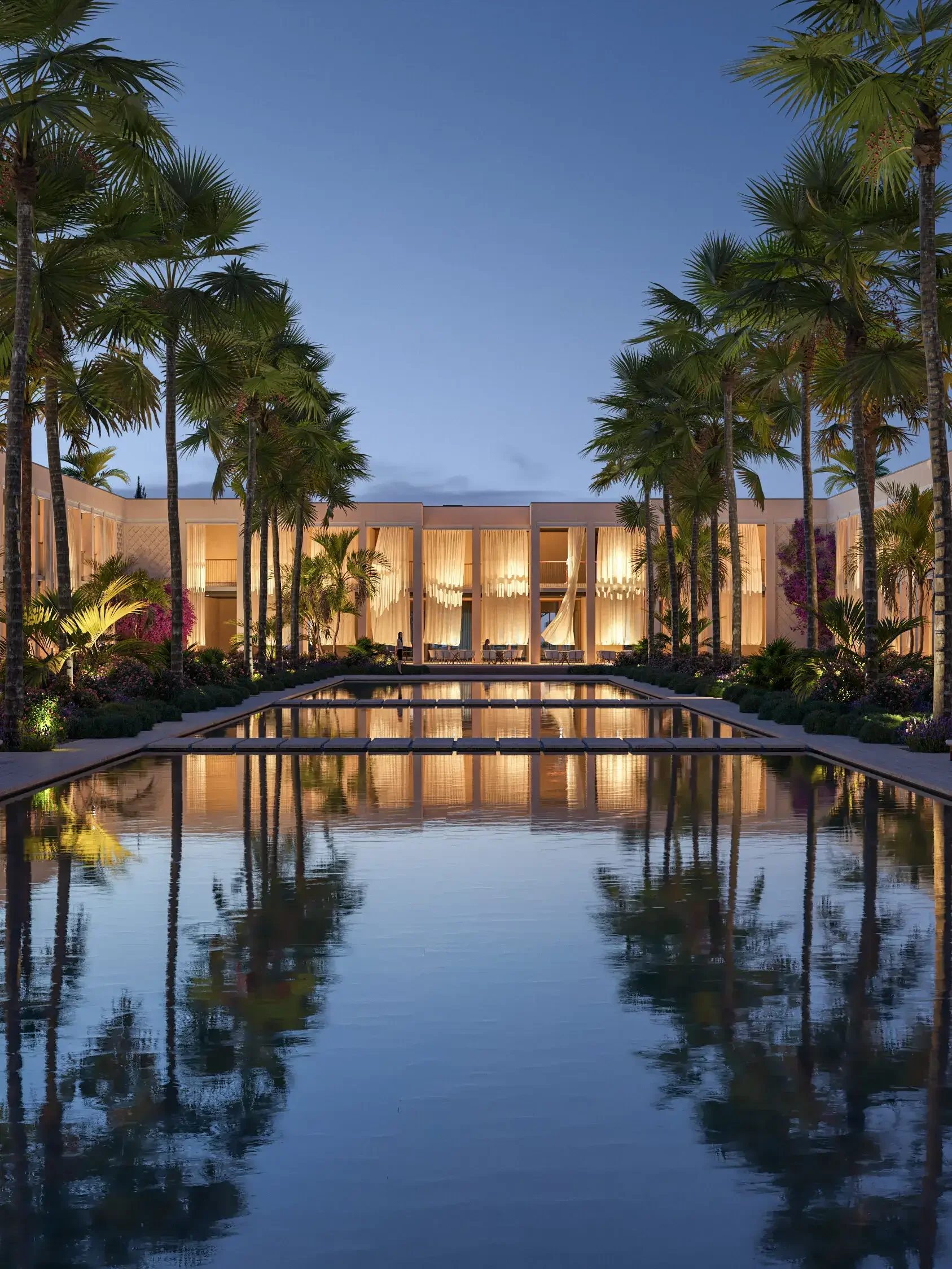 Tall palm trees surround a reflective water feature with glowing lights, leading to a modern building with large curtains, under a twilight sky.