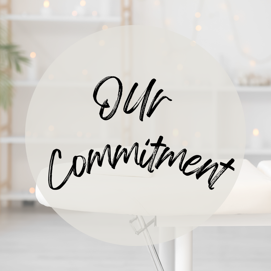 Decorative sign with the words 'Our Commitment' in black handwritten font on a semi-transparent white circle, set against a light, blurred workspace background.