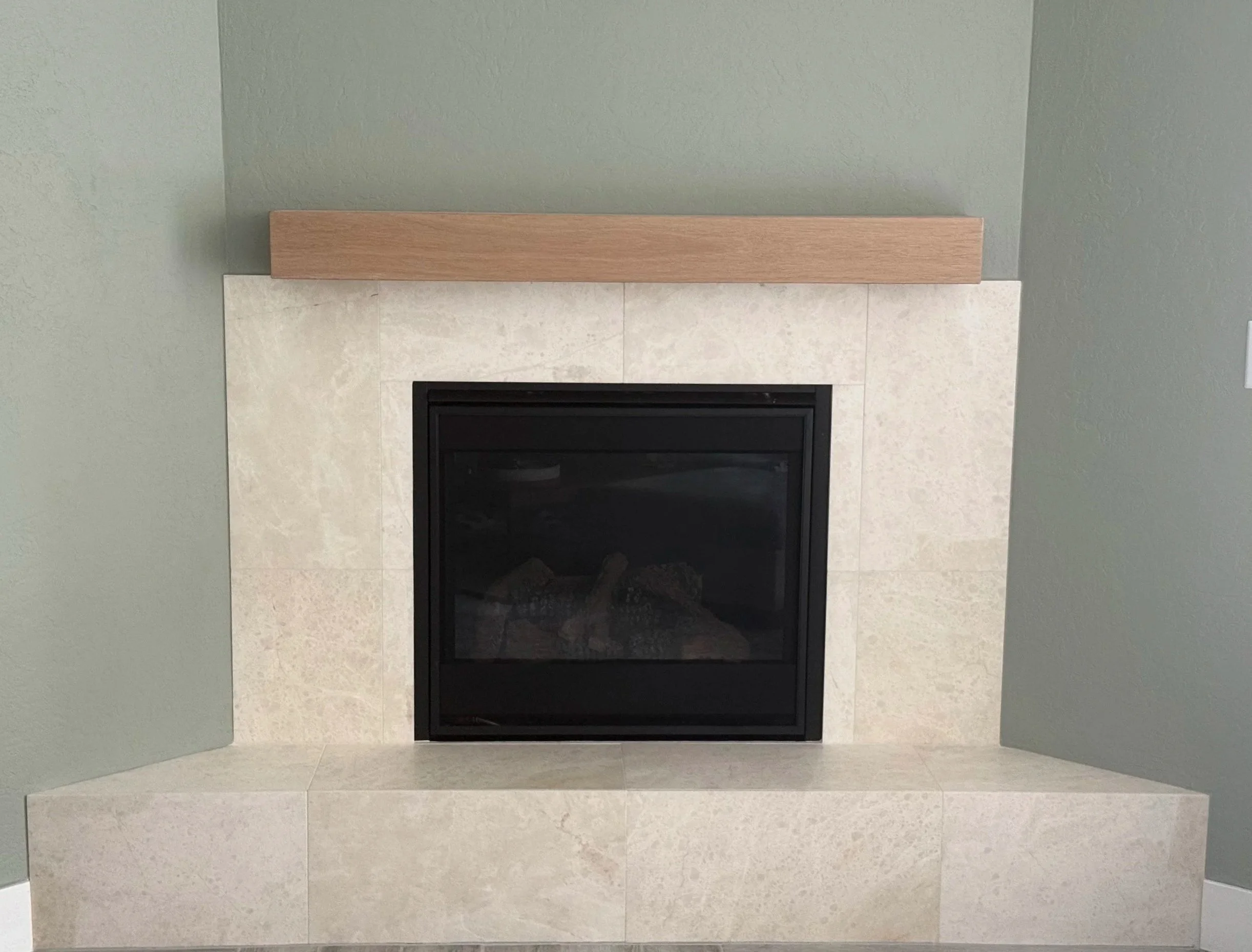 Modern tile fireplace surround with large-format beige tile installed by Solid Ground Tile Co. in Southern Oregon
