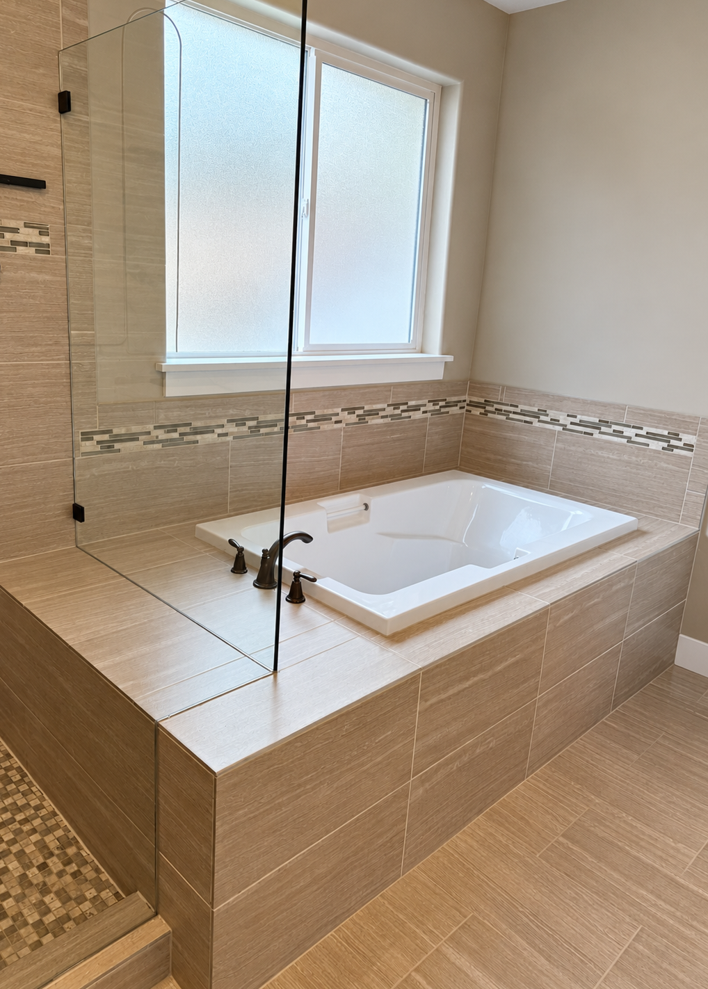 Primary bathroom before remodel with built-in soaking tub and beige tile surround.