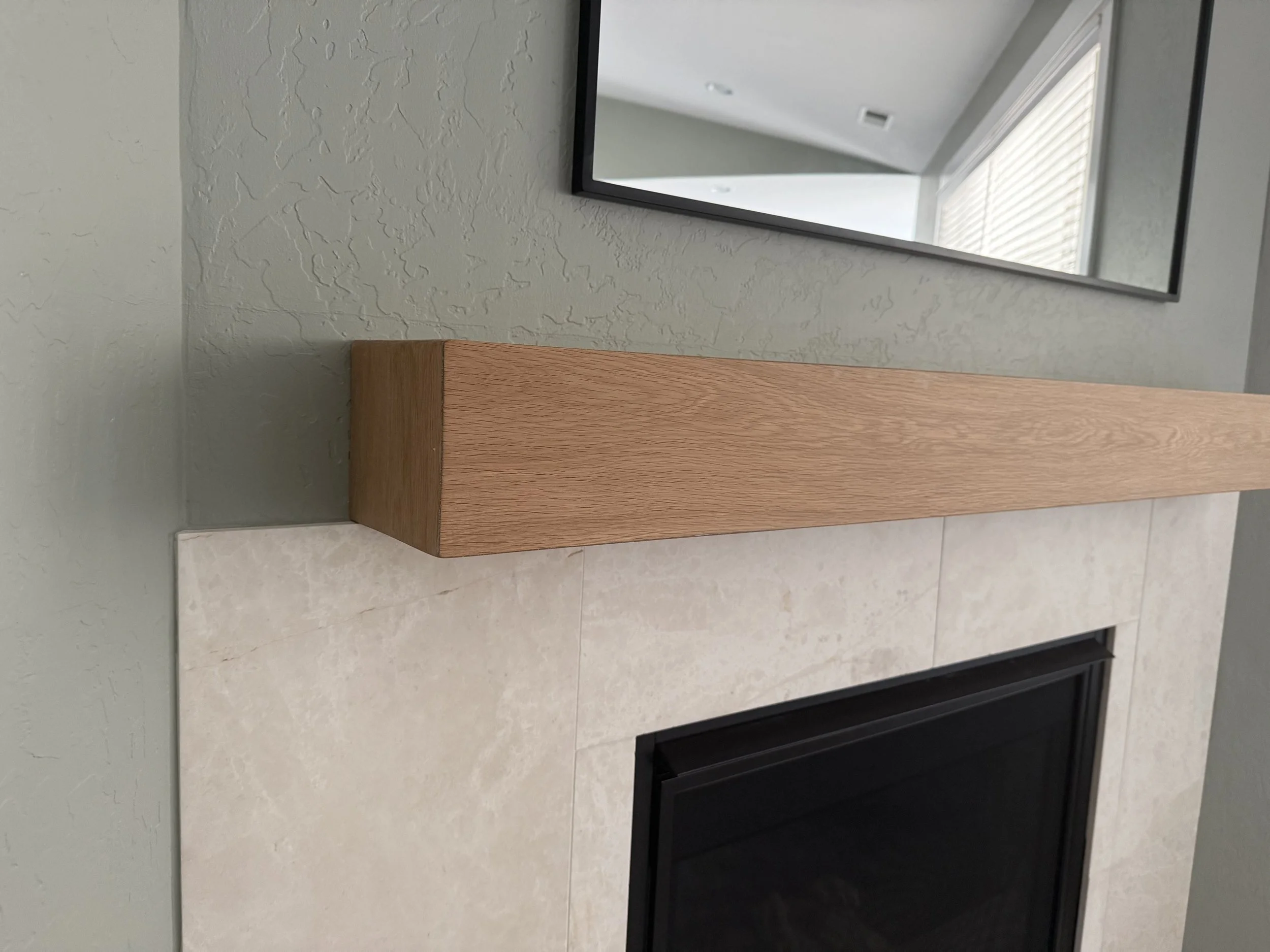 Custom white oak mantel before finishing, showing precise mitered corner detail