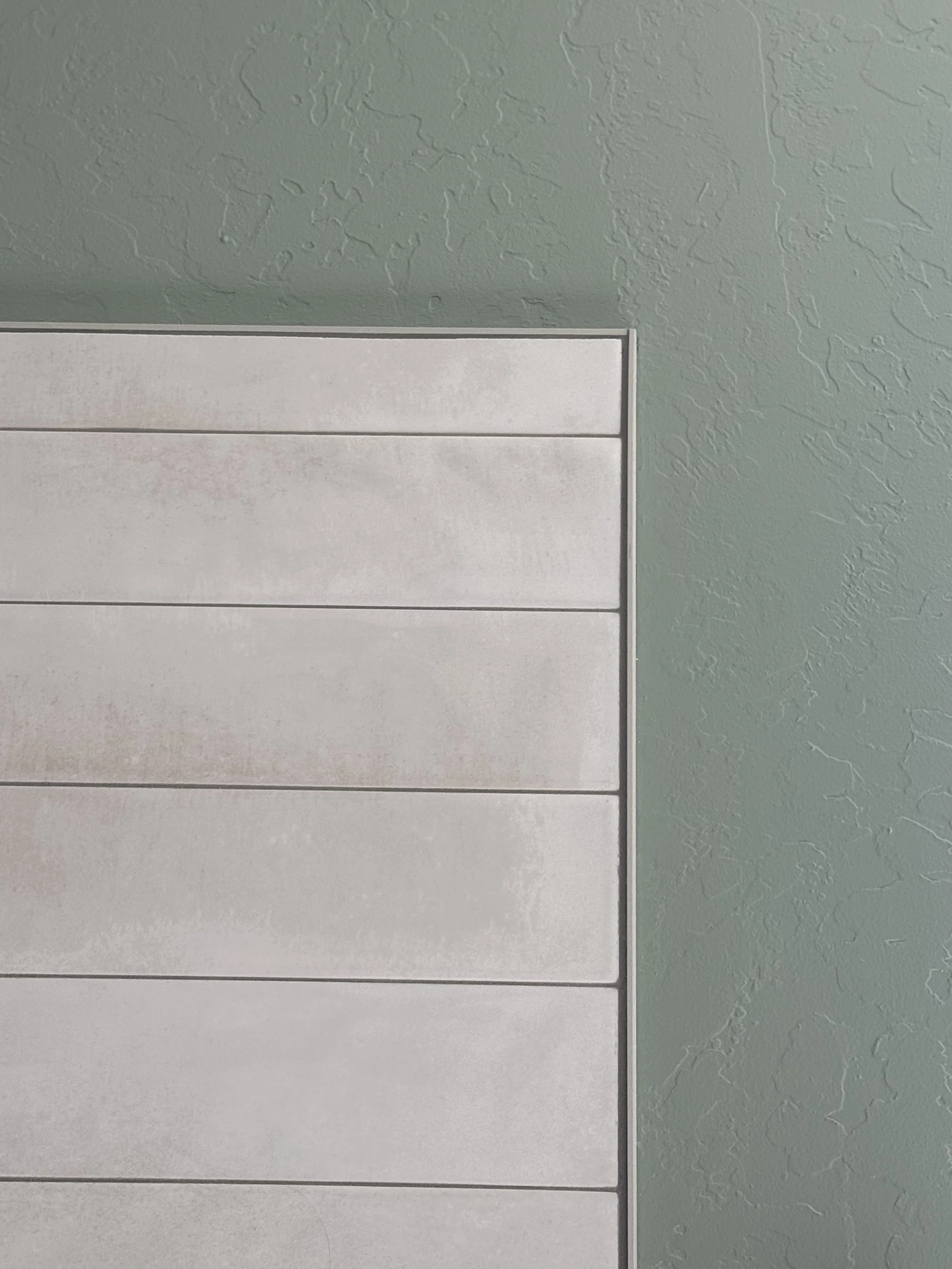 Close-up of a Schluter tile edge profile providing a clean finished transition in a custom tile installation.