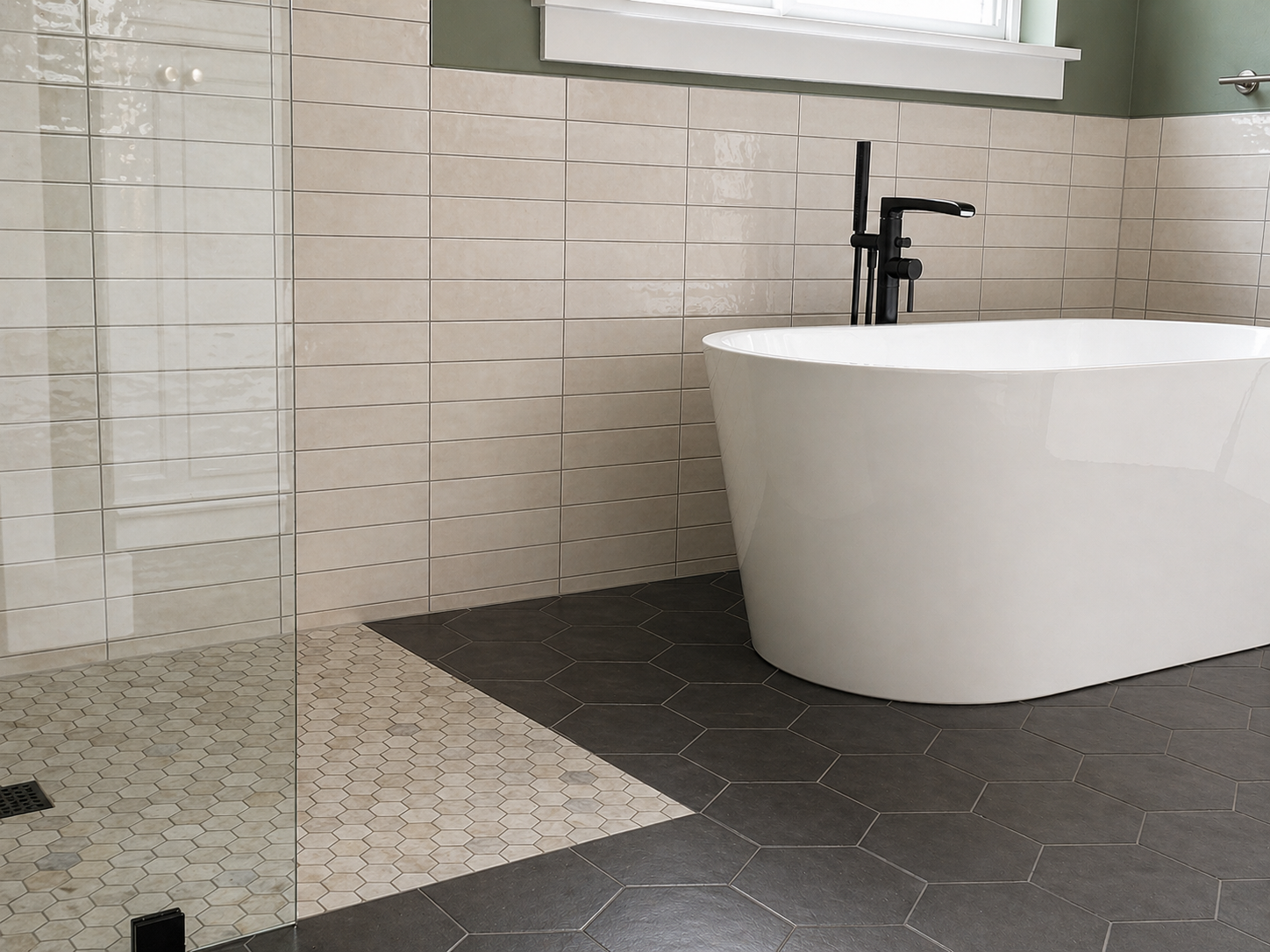 Remodeled primary bathroom with freestanding tub, charcoal hex tile flooring and tiled wall surround.