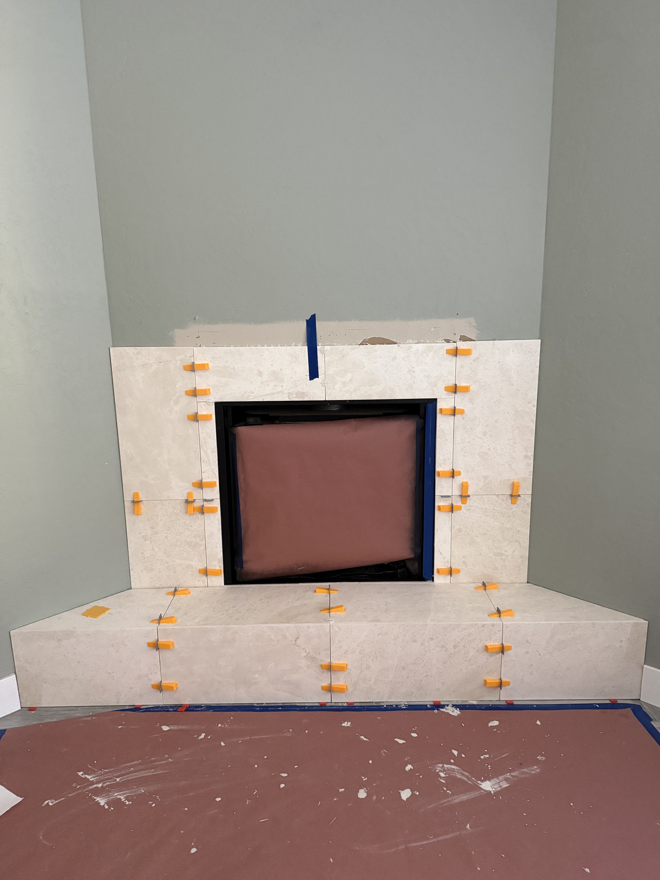 Large-format natural stone tile being installed with careful layout and alignment.