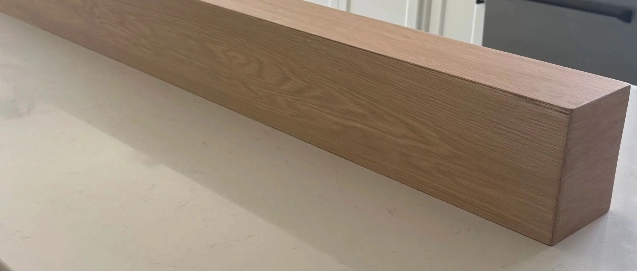 Custom white oak floating fireplace mantel handcrafted by Solid Ground Tile Co.