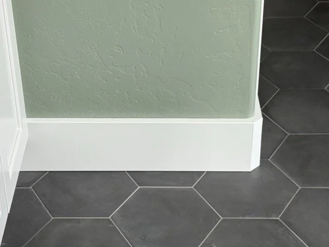 Crisp tile installation with clean baseboard and trim detailing in a remodeled space.