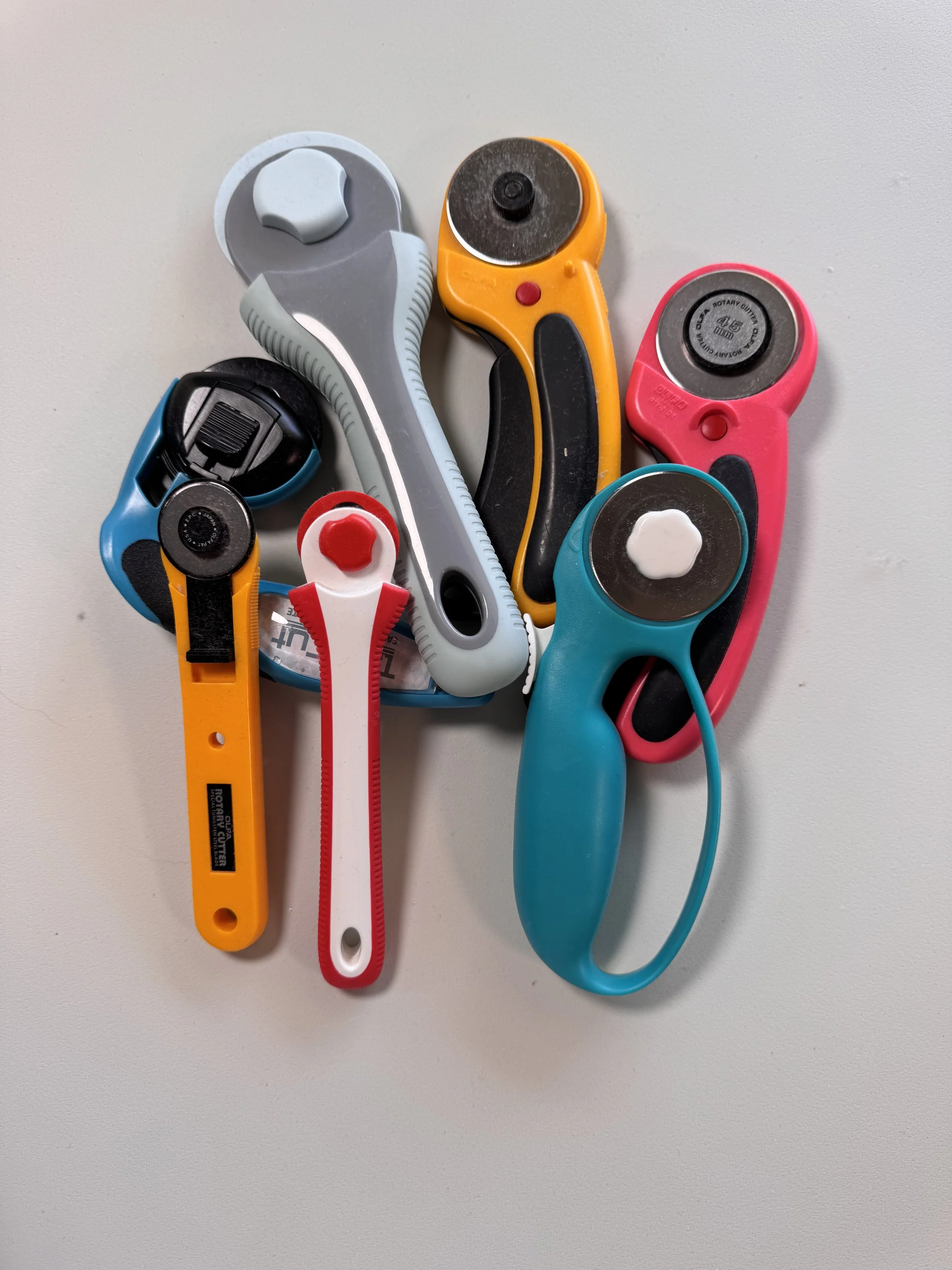 Rotary cutters, quilting rulers, scissors, and cutting tools used for sewing and quilting.
