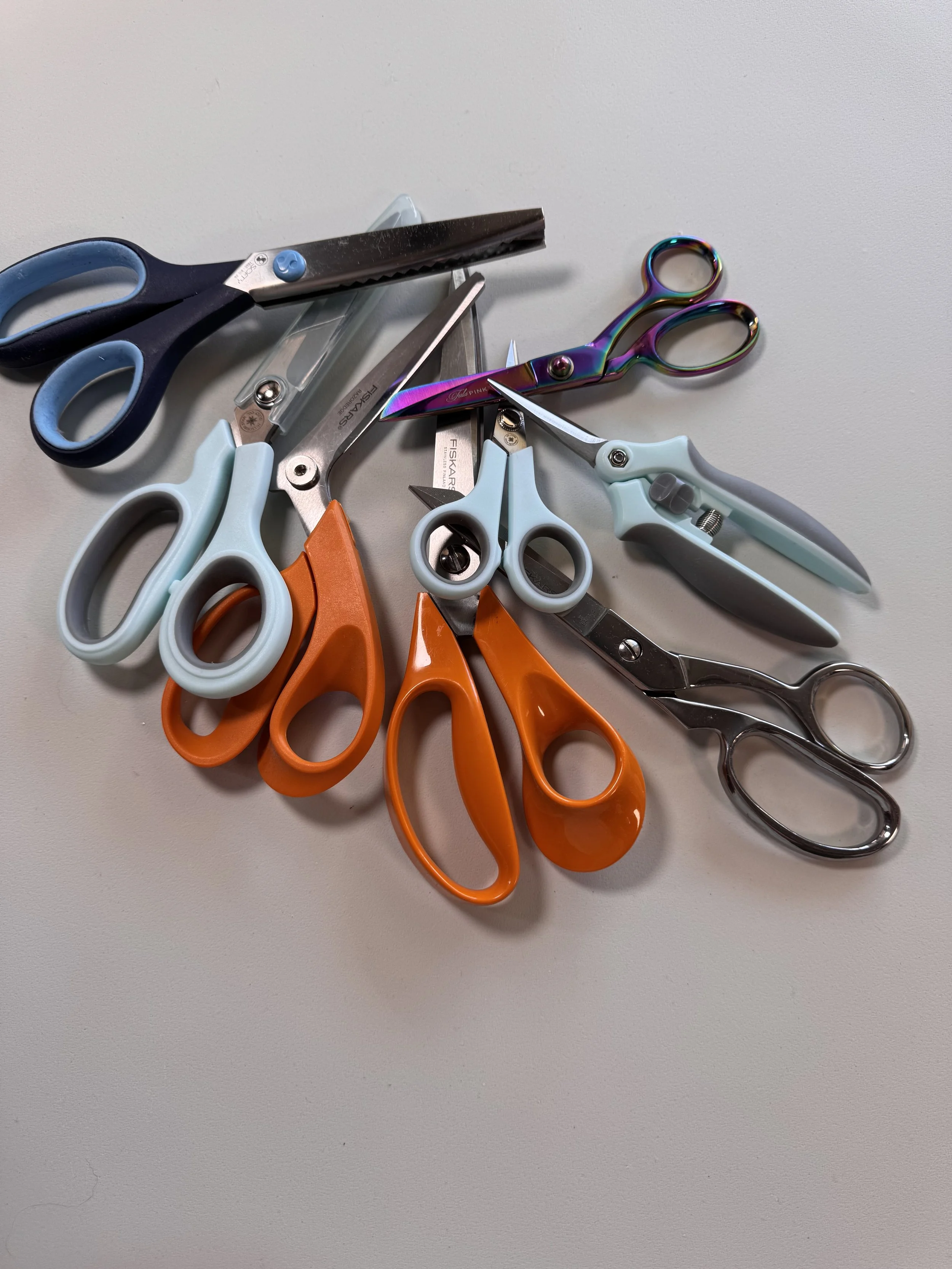 Rotary cutters, quilting rulers, scissors, and cutting tools used for sewing and quilting.