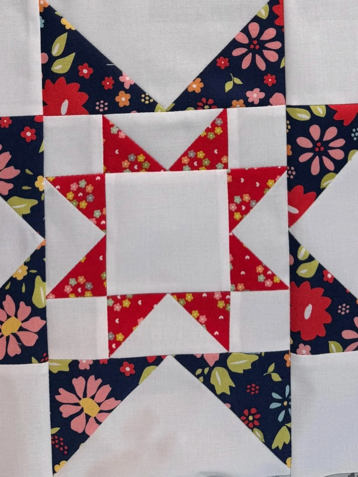 Pieced star quilt block in red and navy fabrics. Explore favorite quilting tools.