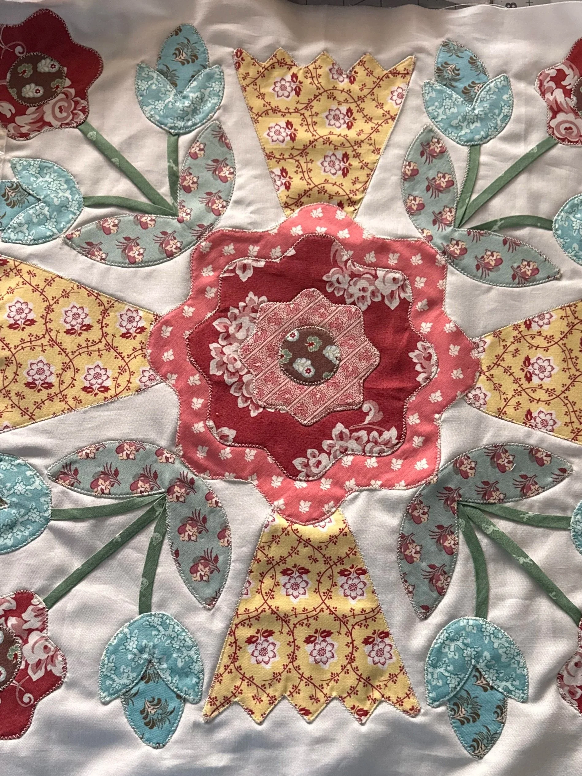 Collection of floral appliqué quilt blocks with colorful flowers and leaves.