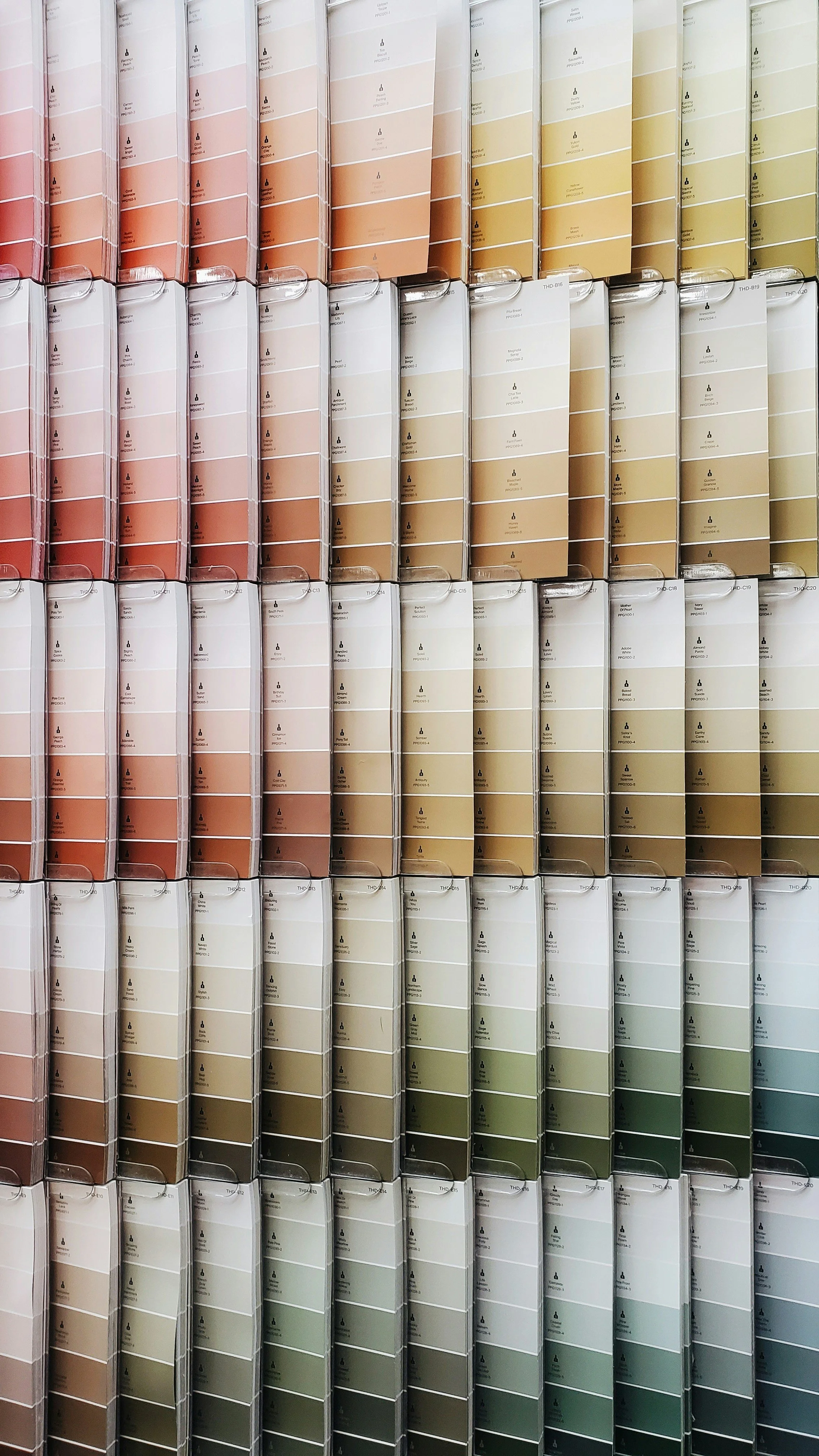 Rows of paint color swatches in various shades from pink to green, organized in a display.
