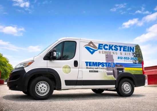 Company van with logo and contact information parked on a paved area with a blue sky and some clouds.