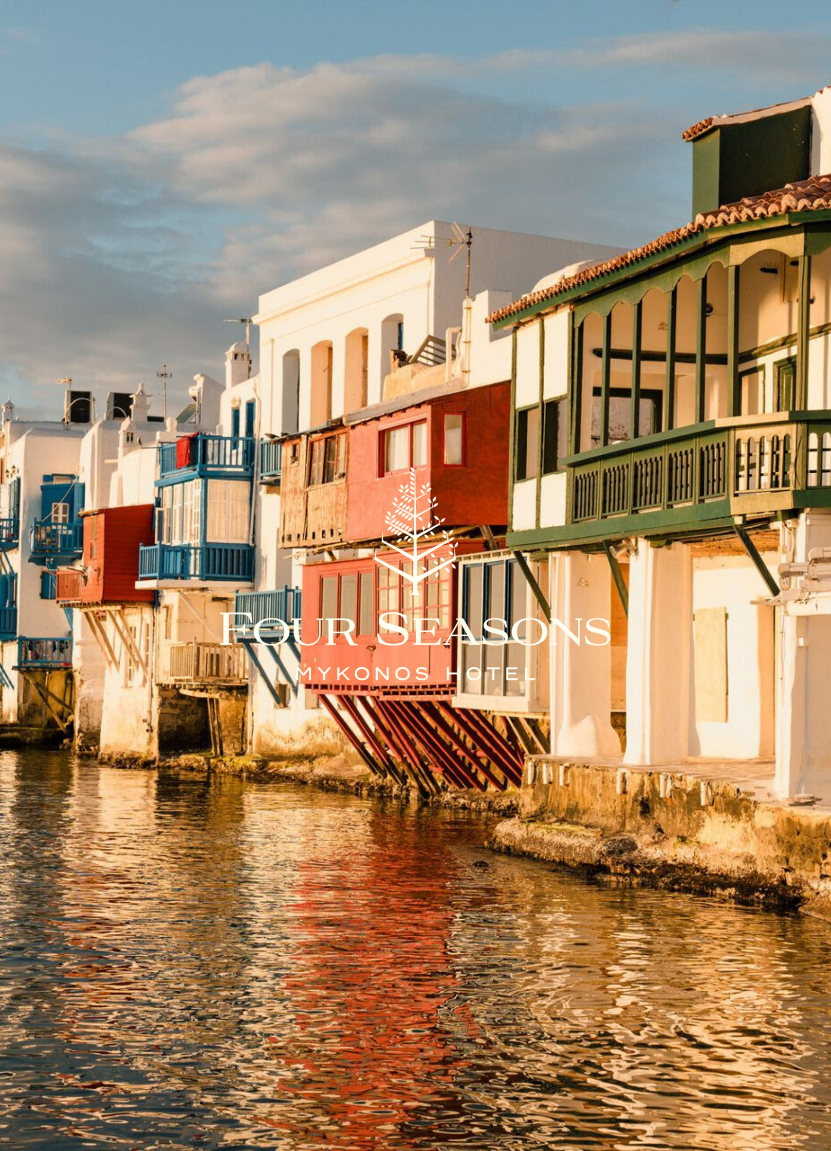 Colorful houses with balconies along the waterfront in Mykonos, Greece, during sunset, reflecting on the water.