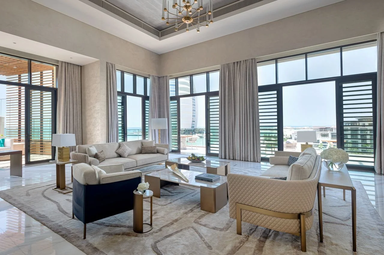 Luxury living room with large windows, contemporary furniture, and ocean view.