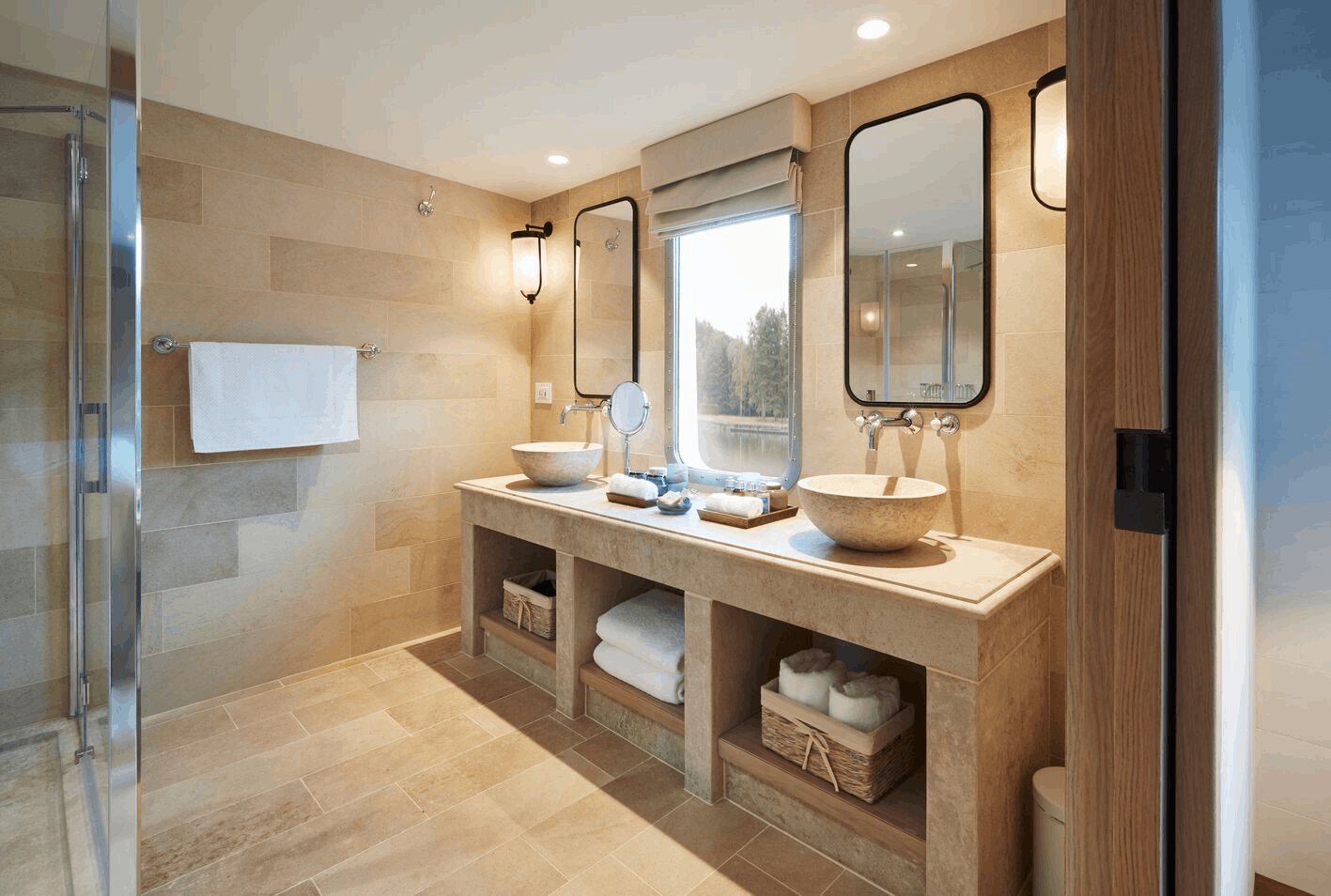 Modern bathroom with dual vessel sinks, large mirrors, beige tile walls and floor, a window with view outside, and towels on a countertop and towel rack.