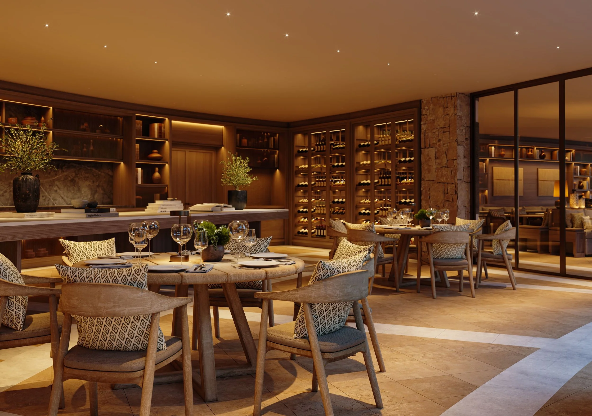 Elegant restaurant interior with round tables set with wine glasses, decorative pillows, potted plants, and books, featuring wooden shelves with vases and a wine rack in the background, illuminated by warm lighting.