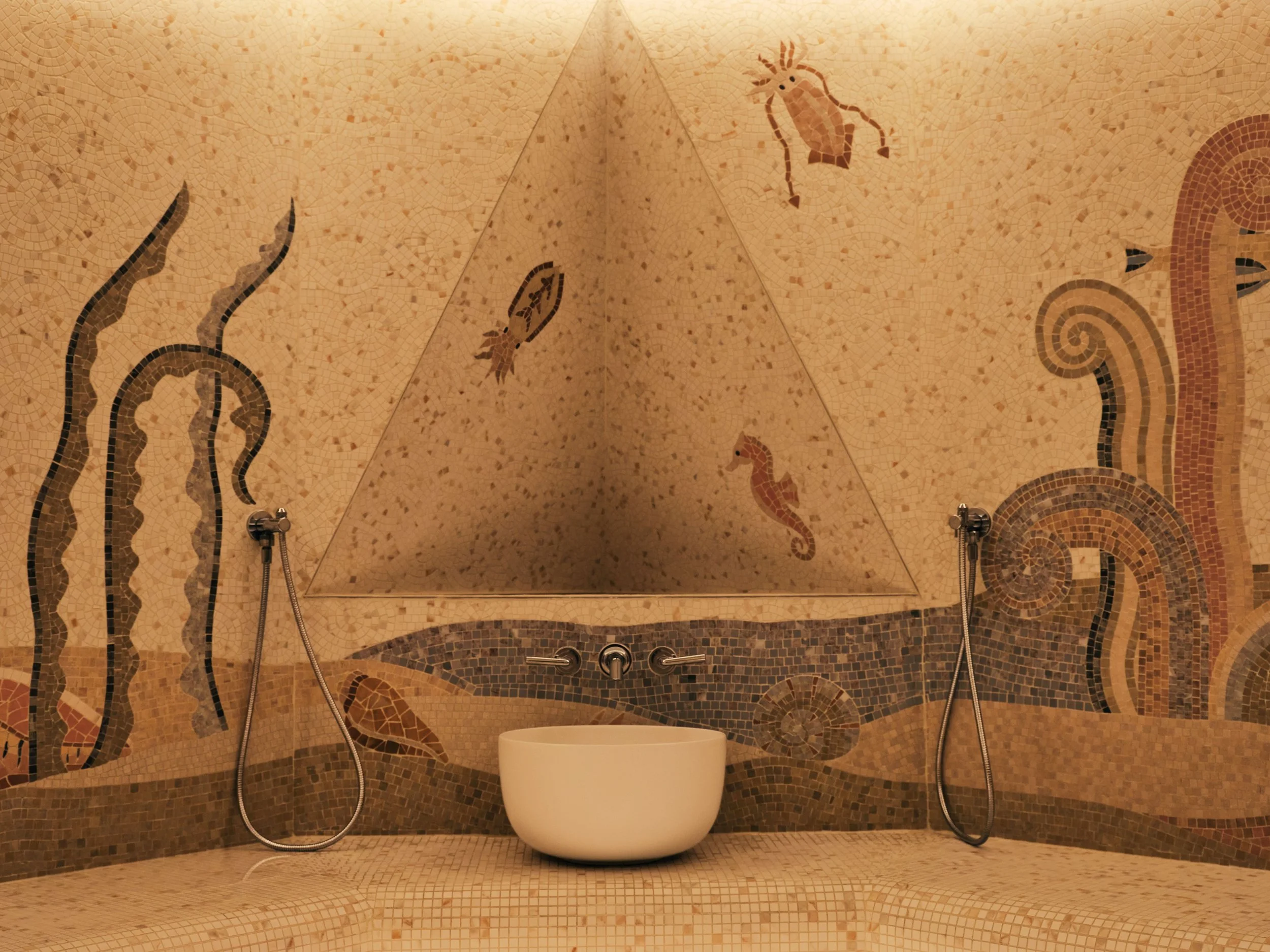 A mosaic tiled shower area with two handheld shower heads and a unique circular white bathtub at the center. The mosaic design includes swirly patterns and a small fish and seahorse design on the wall.