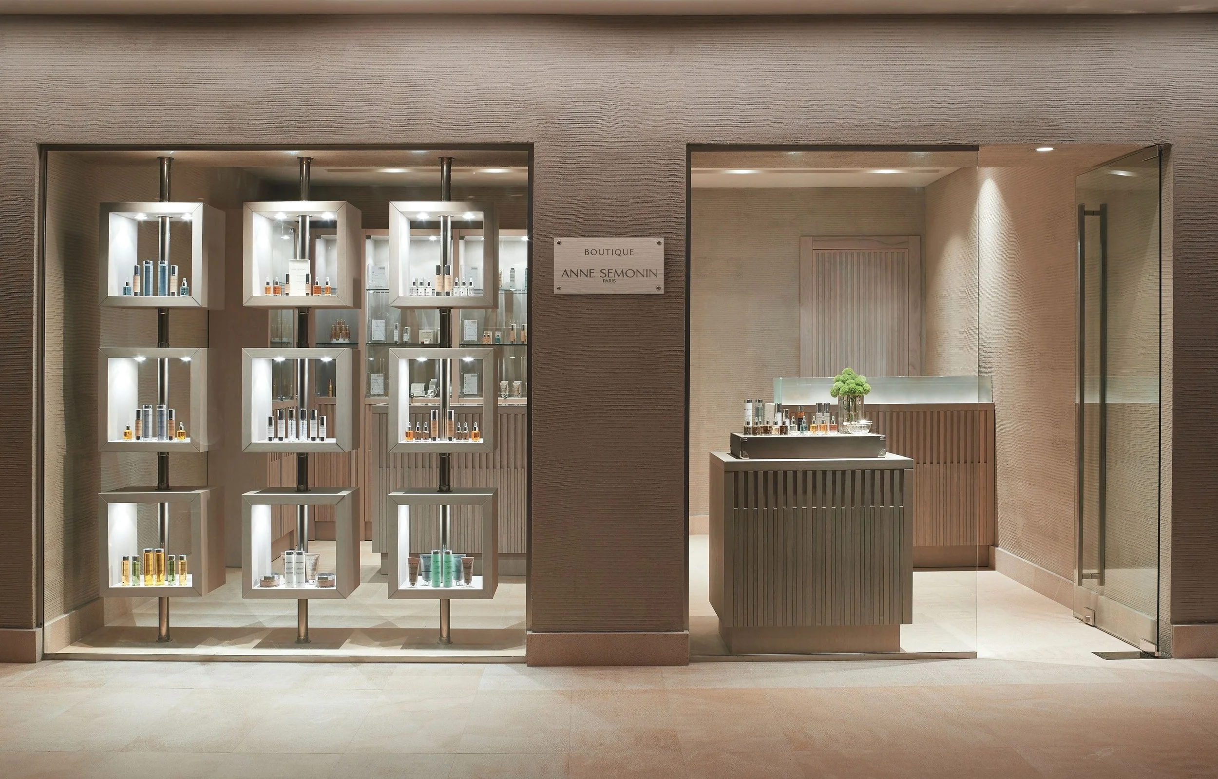  storefront of Anne Semonin boutique with minimalist wooden design and display shelves of skincare products.