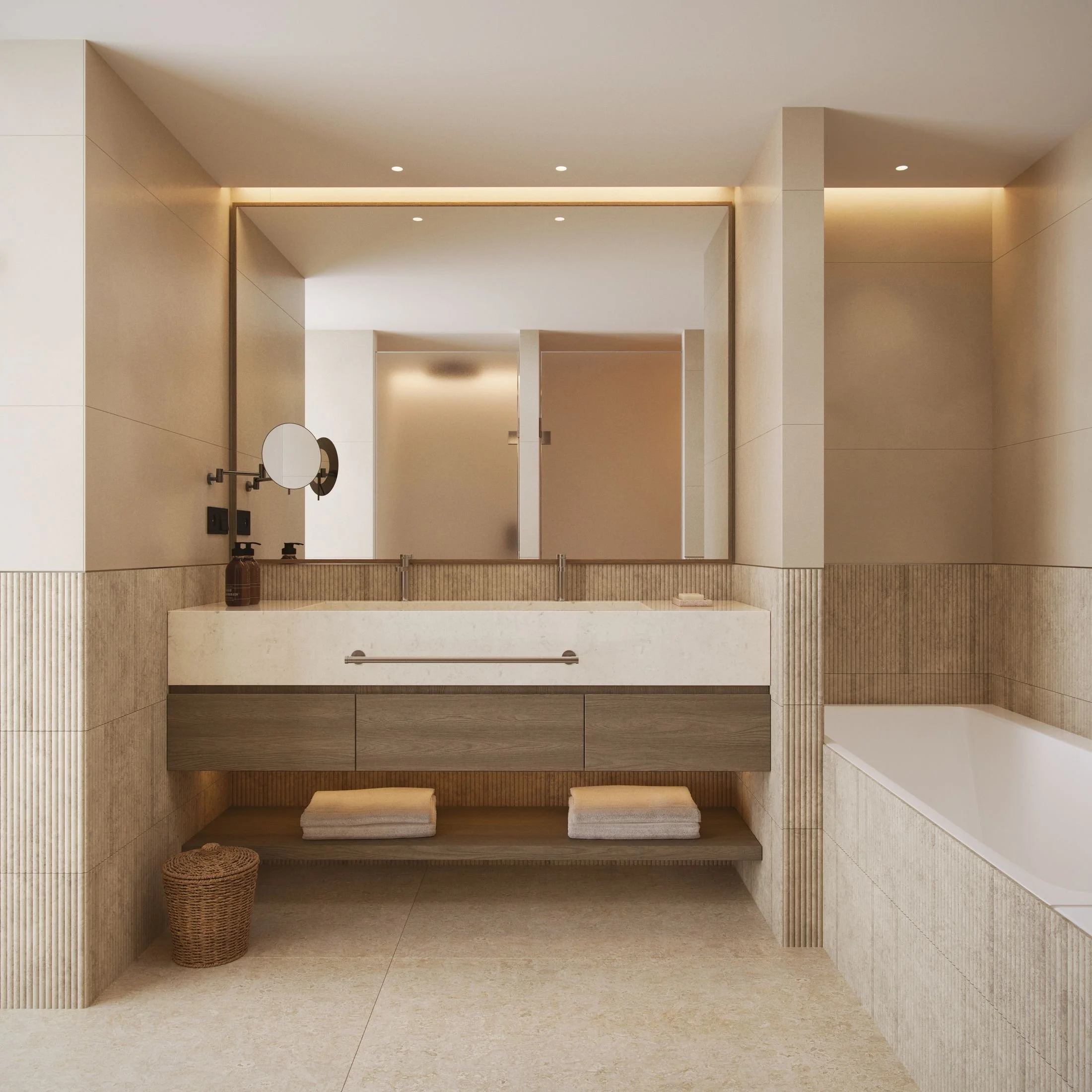 A modern, minimalist bathroom with beige tiled walls and floor. There is a countertop with a round mirror, a soap dispenser, and a decorative jar. Beneath the counter, there are two small square stools. The space is well-lit with recessed ceiling lights and subtle strip lighting above a large mirror.