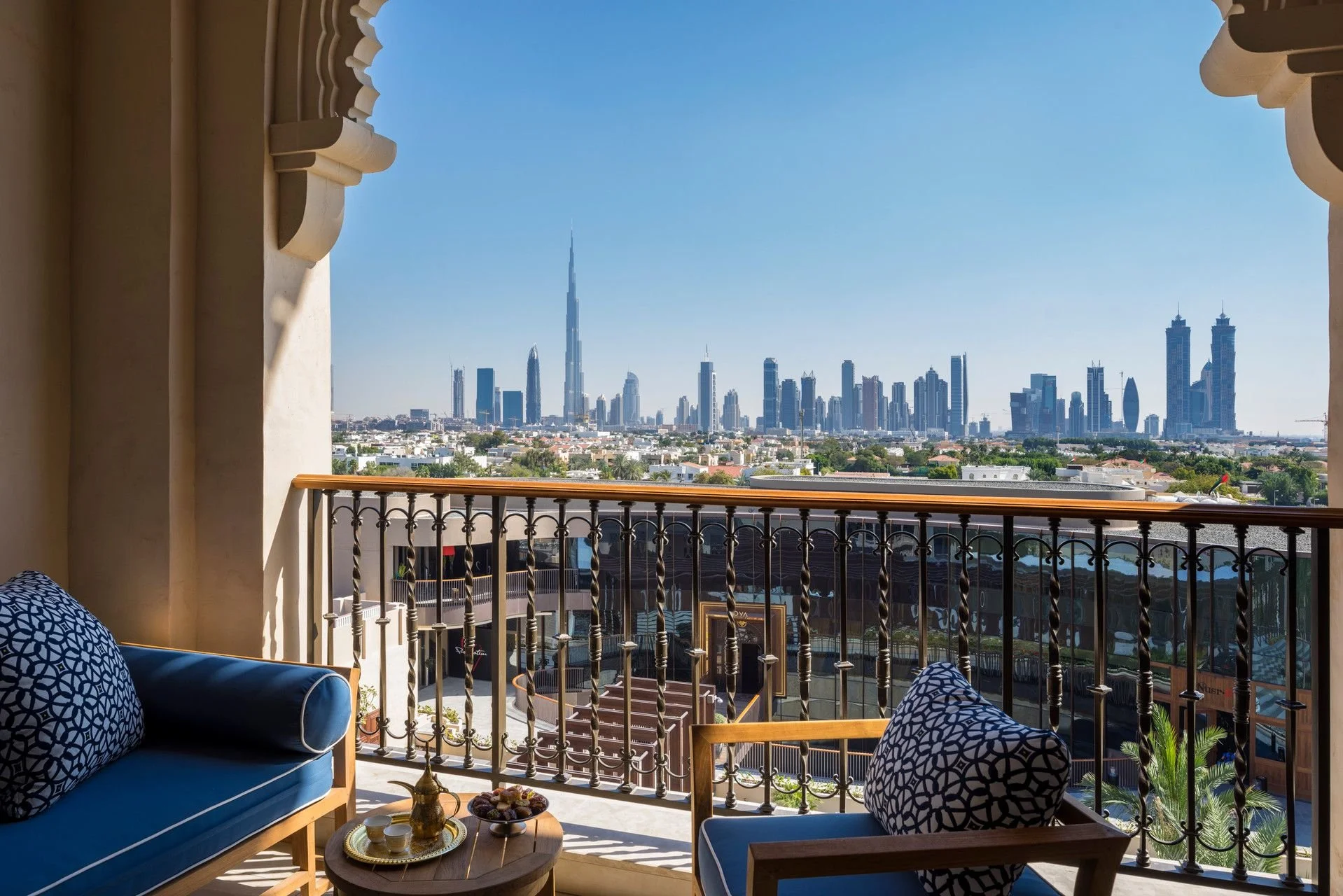 View of Dubai skyline from balcony with decorations and furniture in the foreground.