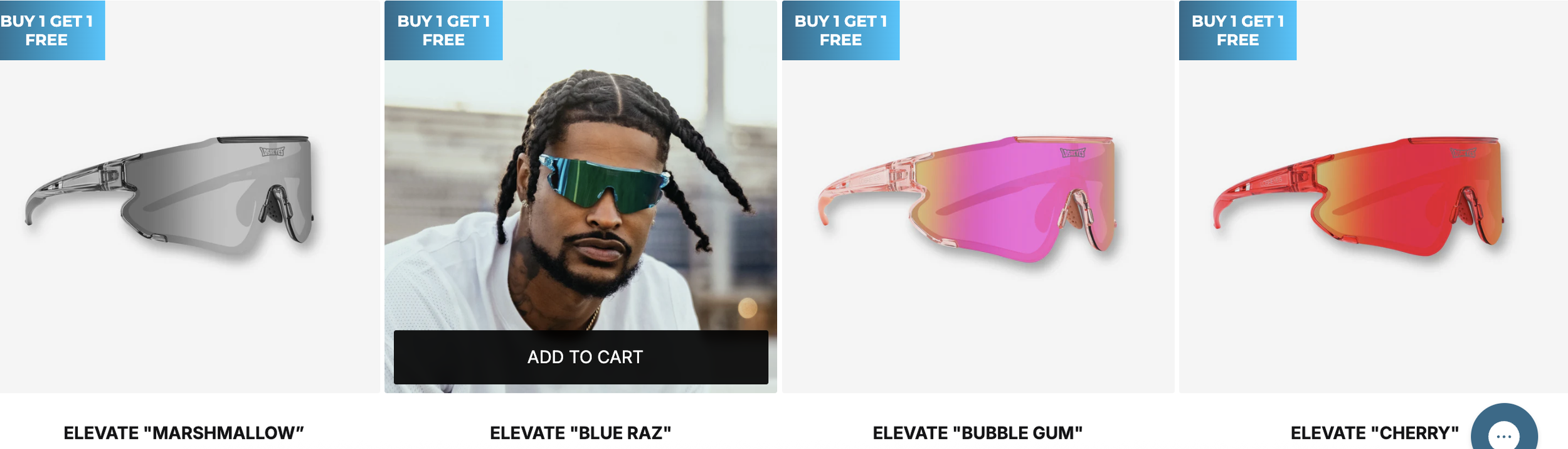 Three pairs of sports sunglasses in different colors and styles, with a promotional banner at the top indicating a buy one get one free sale. The sunglasses are labeled as 'Elevate Marshmallow,' 'Elevate Blue Raz,' 'Elevate Bubble Gum,' and 'Elevate Cherry.' One pair of sunglasses is modeled by a man with dreadlocks and sunglasses from the 'Blue Raz' style.