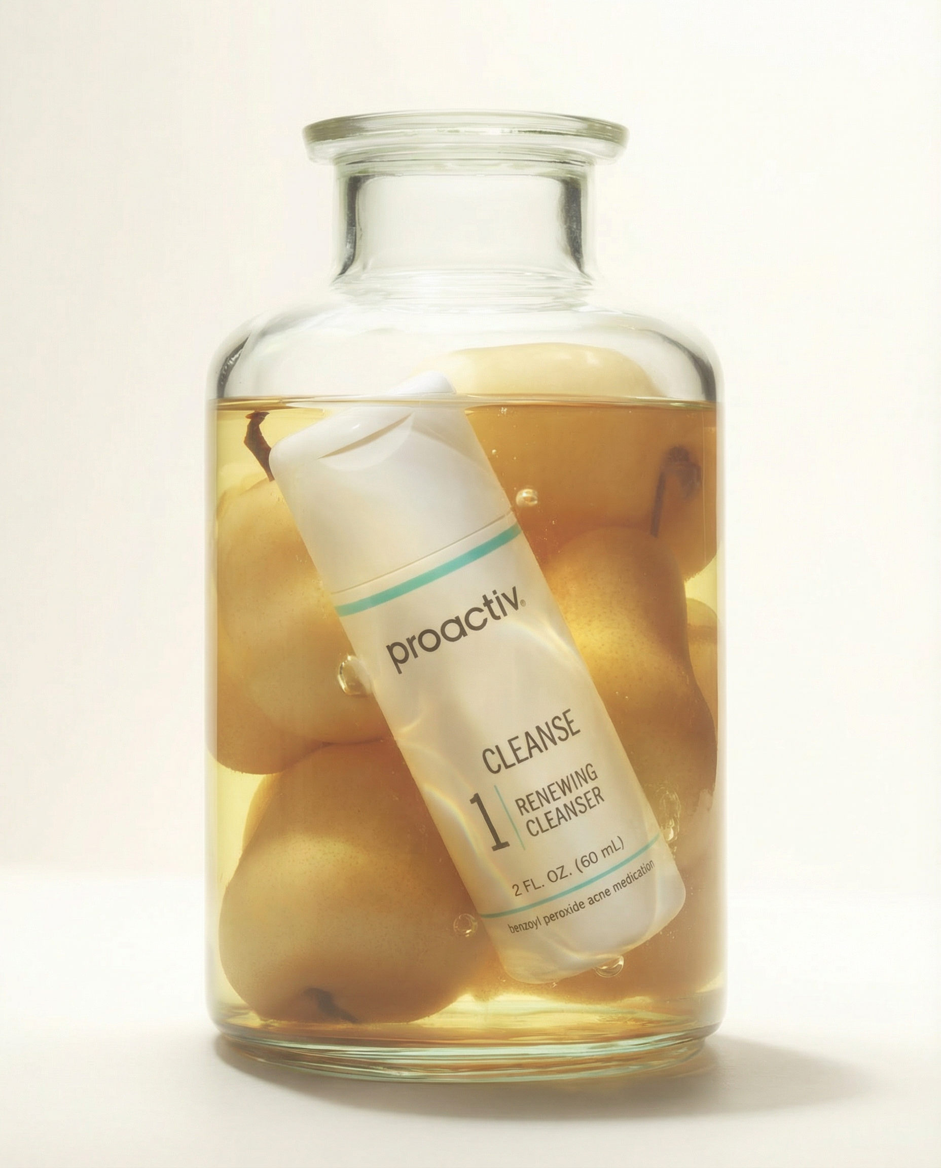 A clear glass jar containing a liquid with a white tube labeled 'proactiv' inside it in a close-up shot.