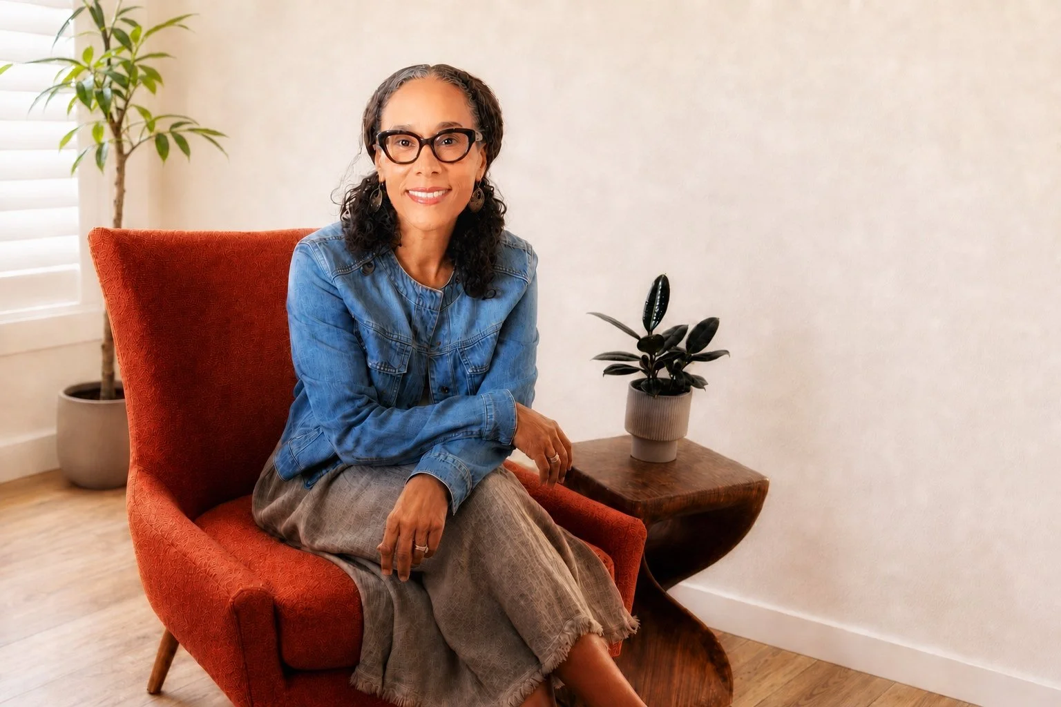 Shevette Swayze Venters seated in an orange chair in a light filled room