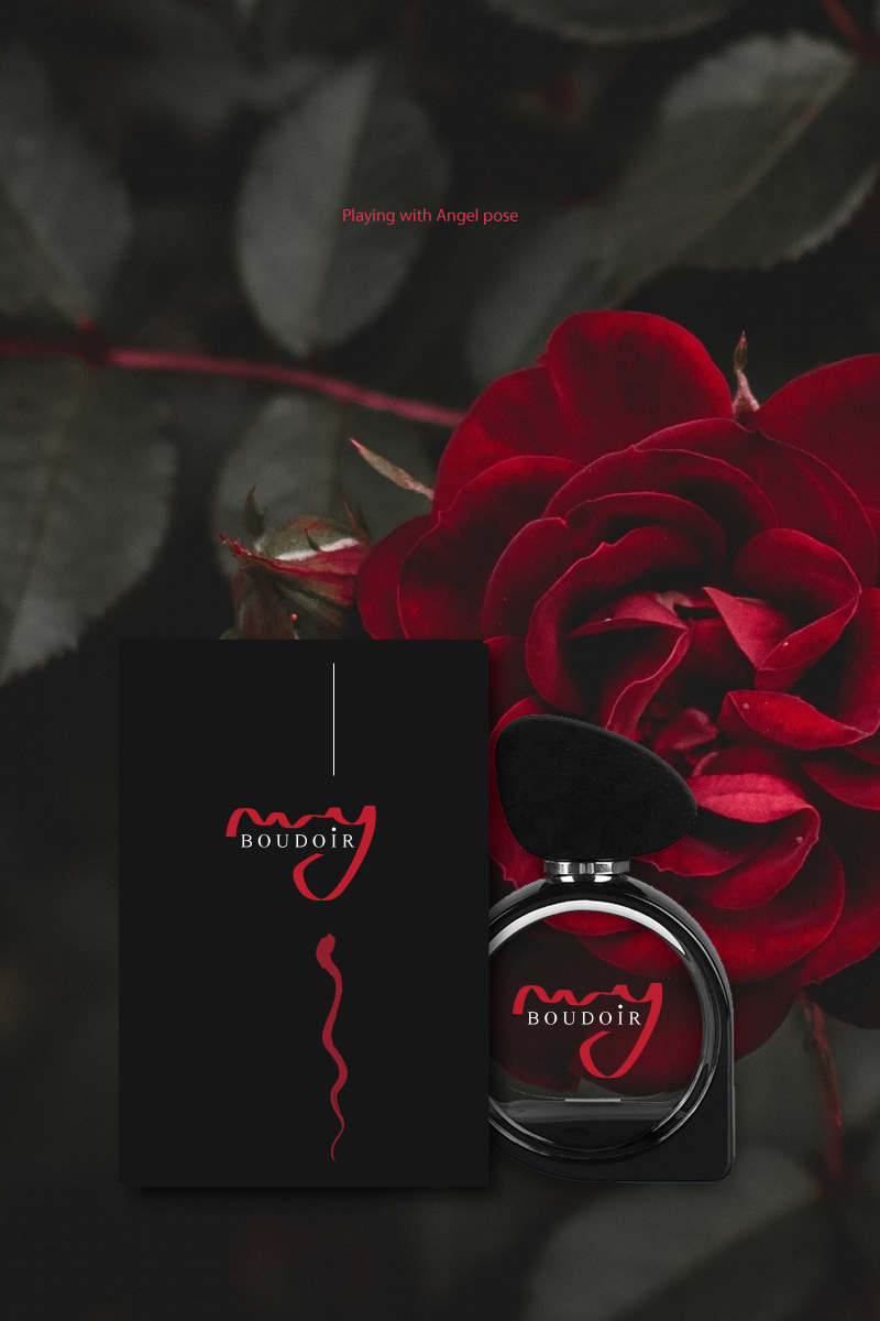 A black box and a perfume bottle labeled 'BOU_DOIR' with a red letter 'J', placed in front of a dark background with red roses and green leaves.