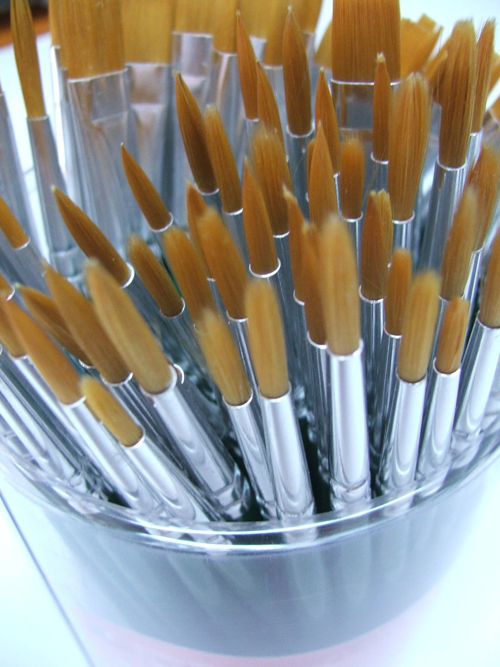 Close-up of a stainless steel container filled with wooden sticks or skewers.