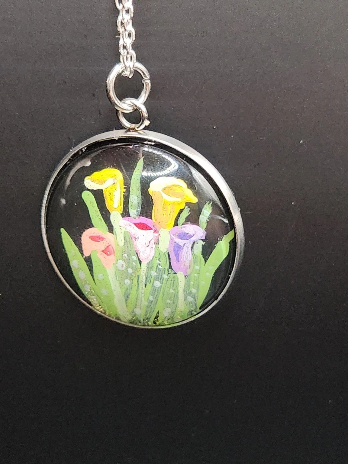 Colorful calla lilies art pendant shown on a silver-tone chain against a dark background. Chain not included.