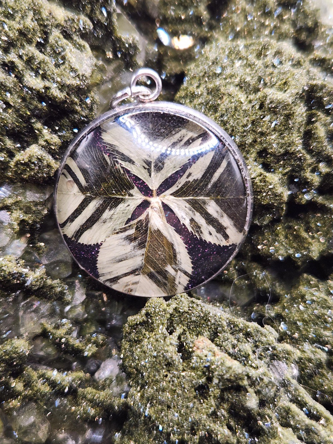 Perfectly Imperfect I002: patterned real clover pendant with purple glitter on a crystal display. Display not included.
