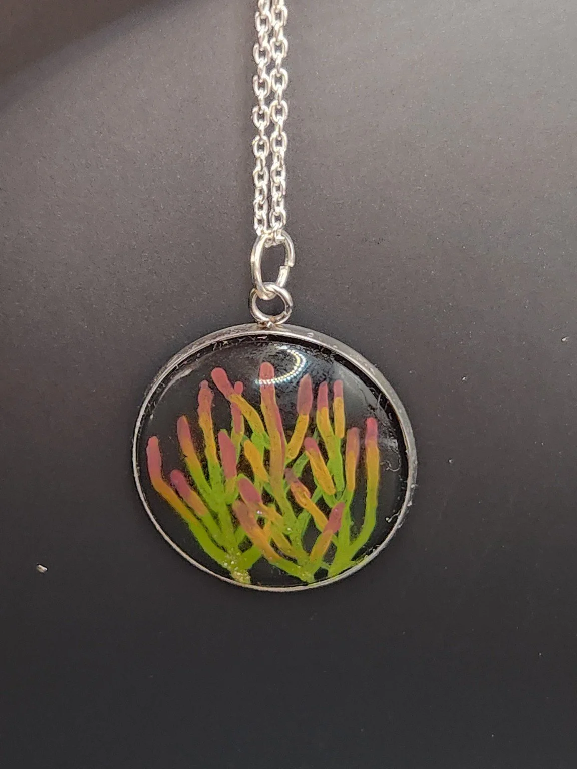 Colorful firestick cactus art pendant hanging from a silver-tone chain. Chain not included.
