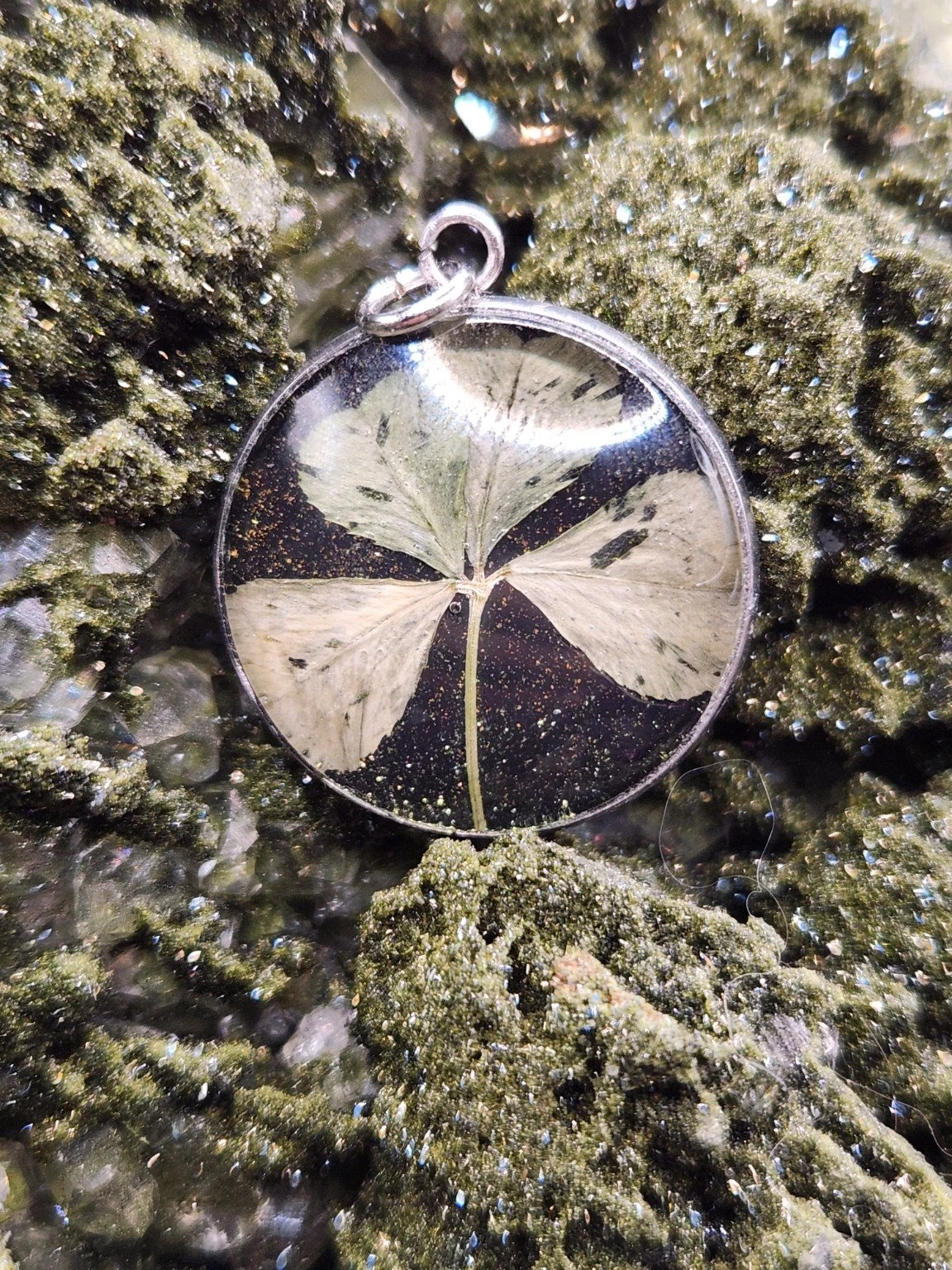 Naturally Unique N005: real four-leaf clover pendant with green glitter on a crystal display. Display not included.