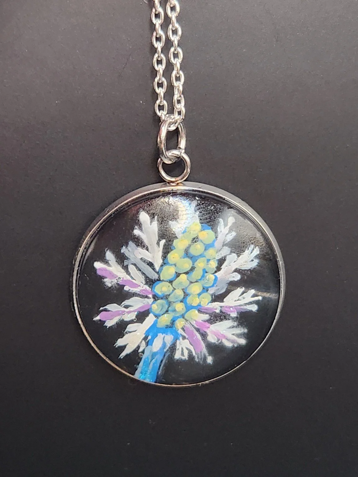 Eryngium sea holly flower art pendant hanging from a silver-tone chain. Chain not included.