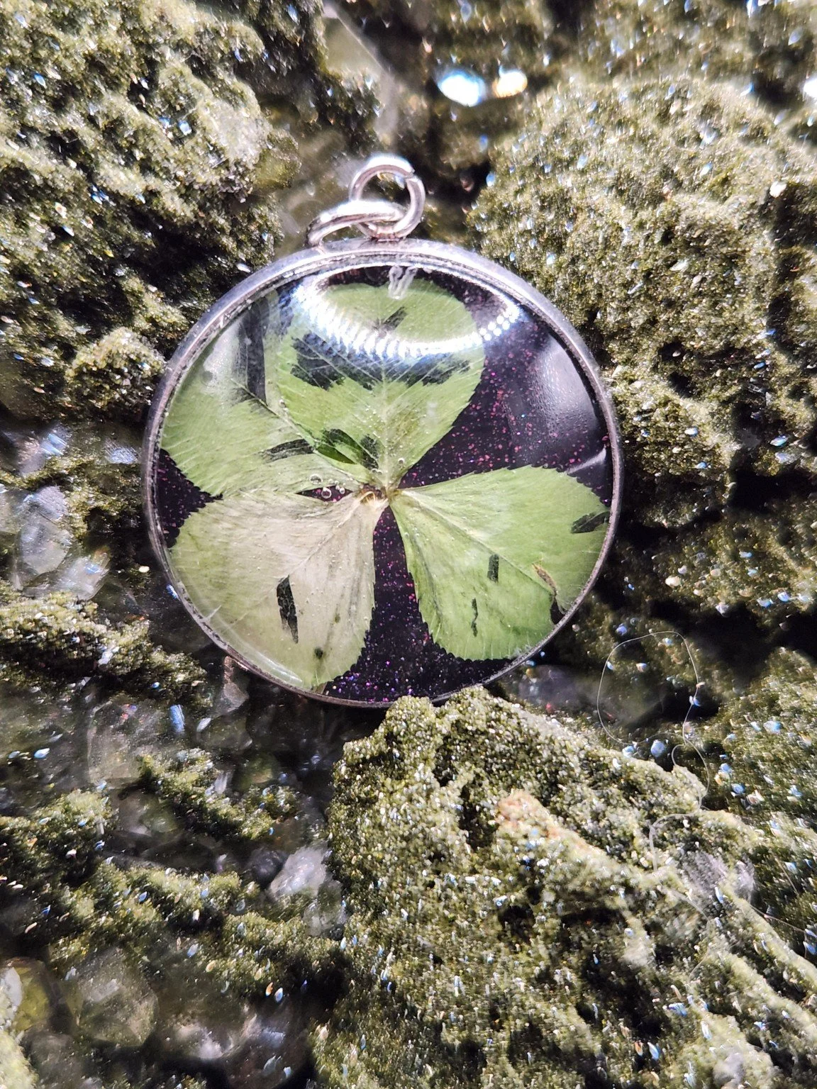 Naturally Unique N006: real four-leaf clover pendant with purple glitter on a crystal display. Display not included.