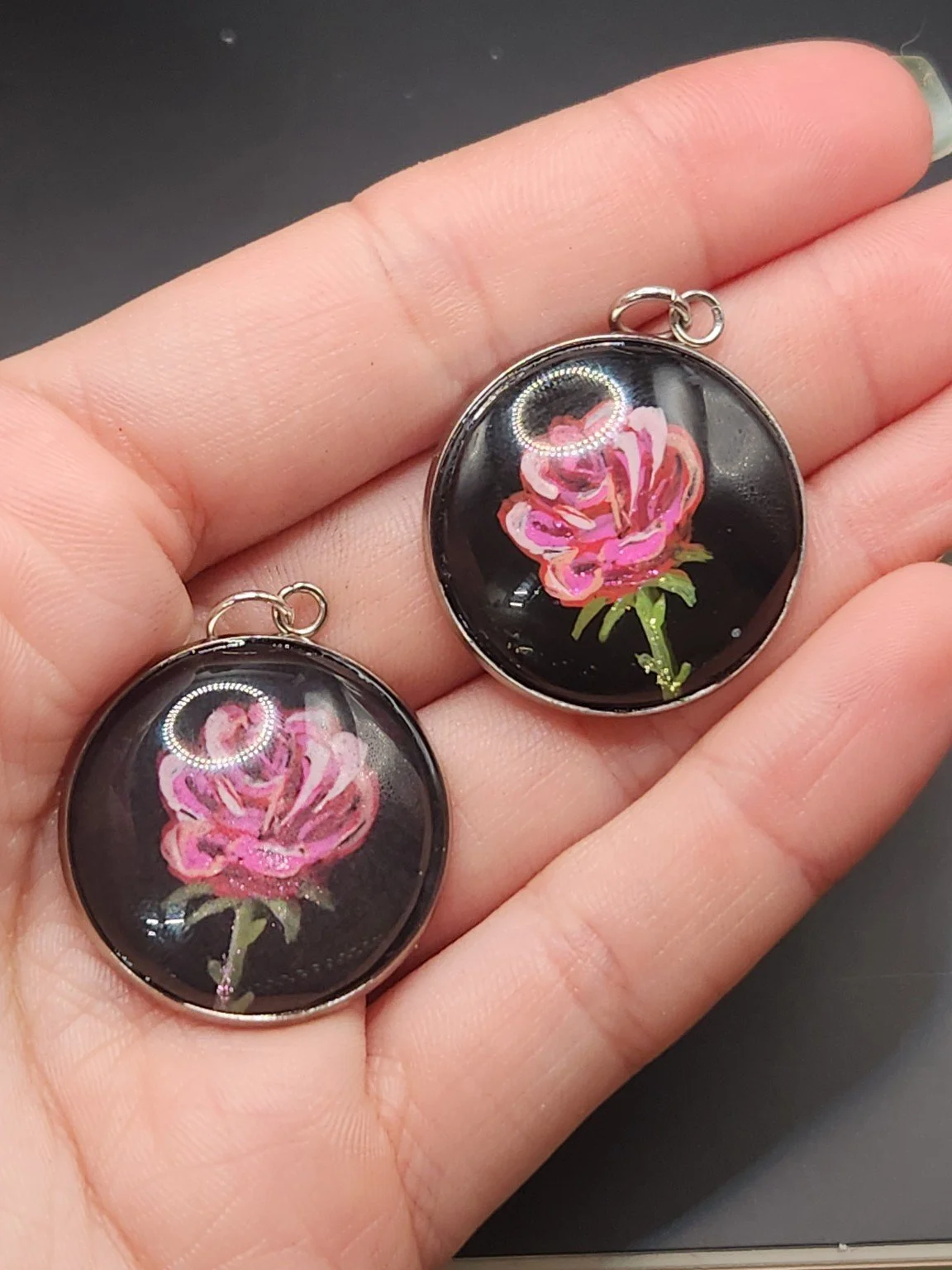 Rose pendant comparison held in a hand: the hand-painted original is at the top right, and the printed reproduction is at the bottom left.