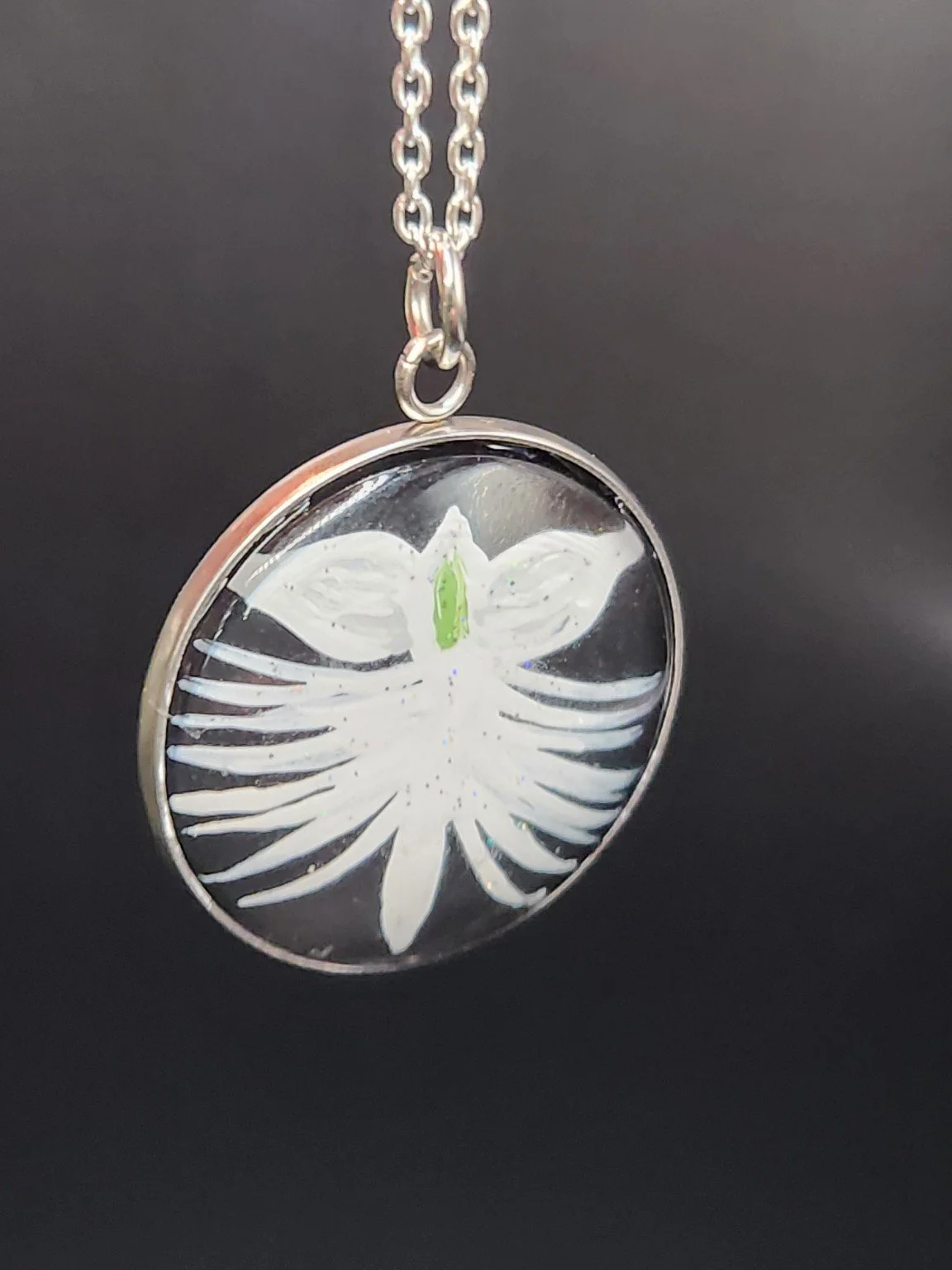 White dove orchid flower art pendant hanging from a silver-tone chain. Chain not included.