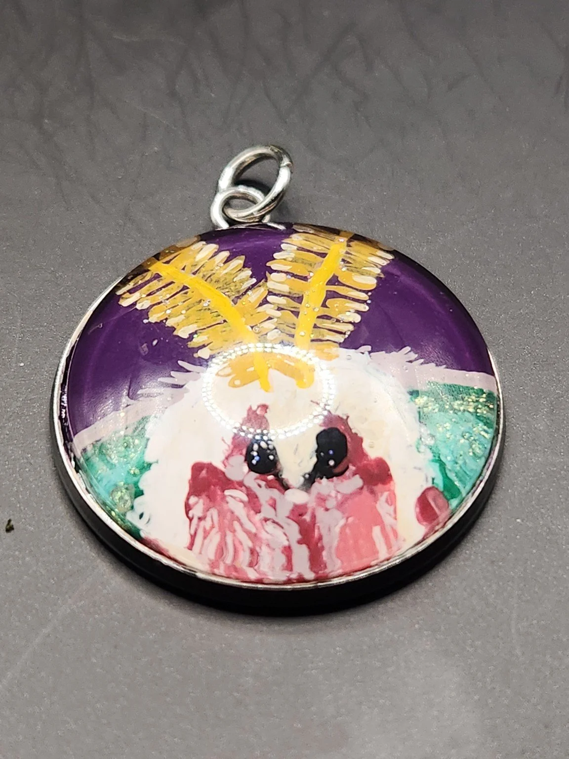 Hand-painted luna moth face original pendant with a purple background, golden antennae, pink facial details, green accents, and glitter.