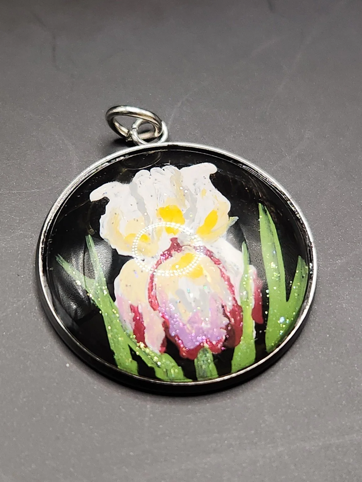 Purple, white and yellow iris flower art pendant with shimmering glitter in a silver-tone bezel.