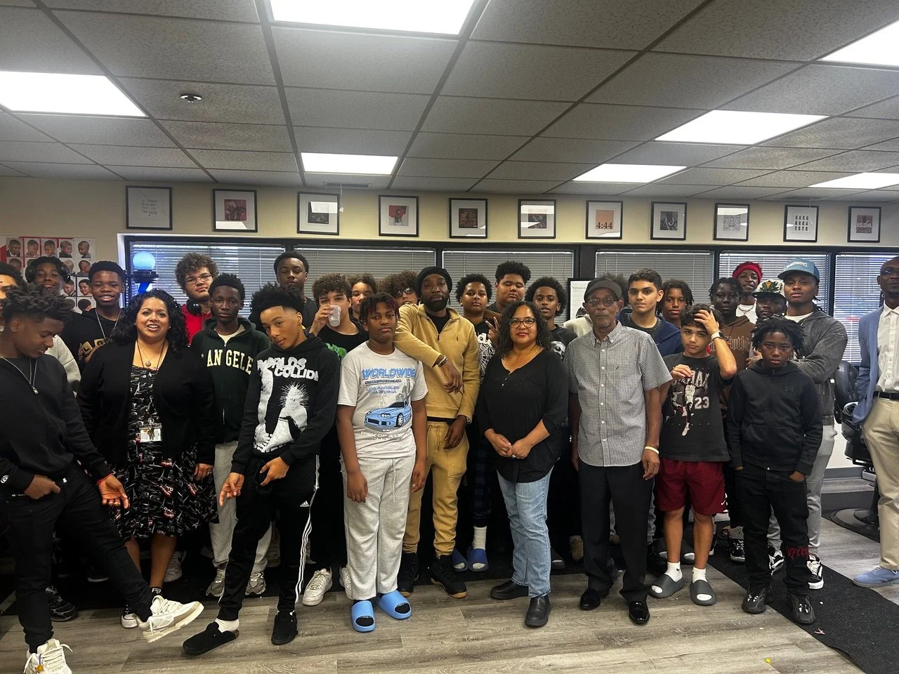 Group of diverse young people and adults gathered in an office setting, posing for a group photo.