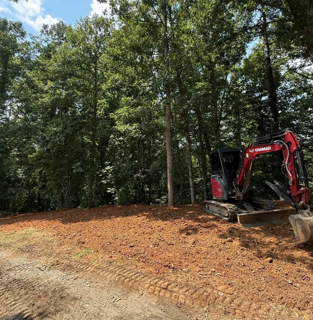 M&S Land Management completing final grade work with an excavator on a wooded property in Weaverville, North Carolina.