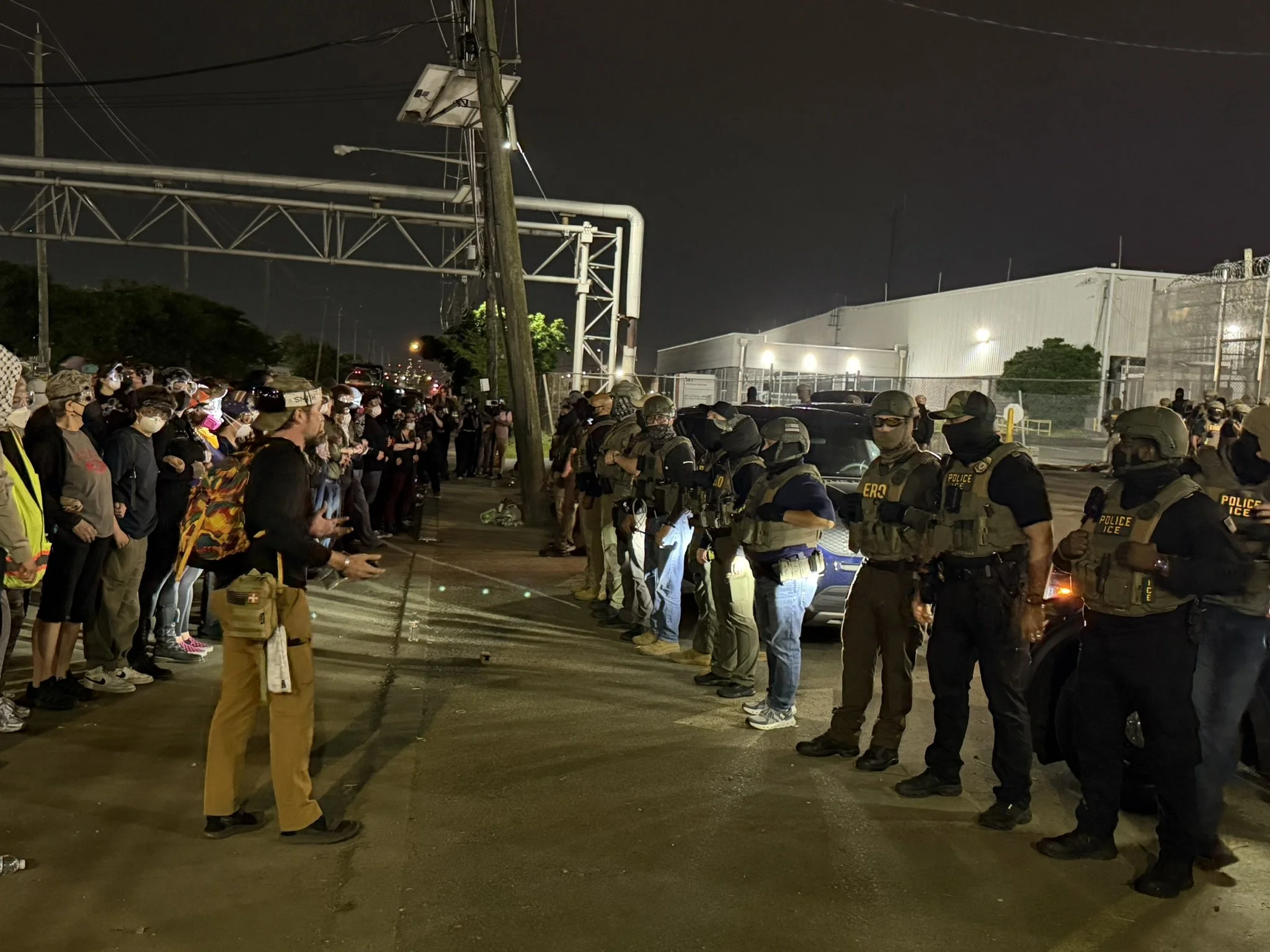 Man protester in between line talking to ICE.JPEG