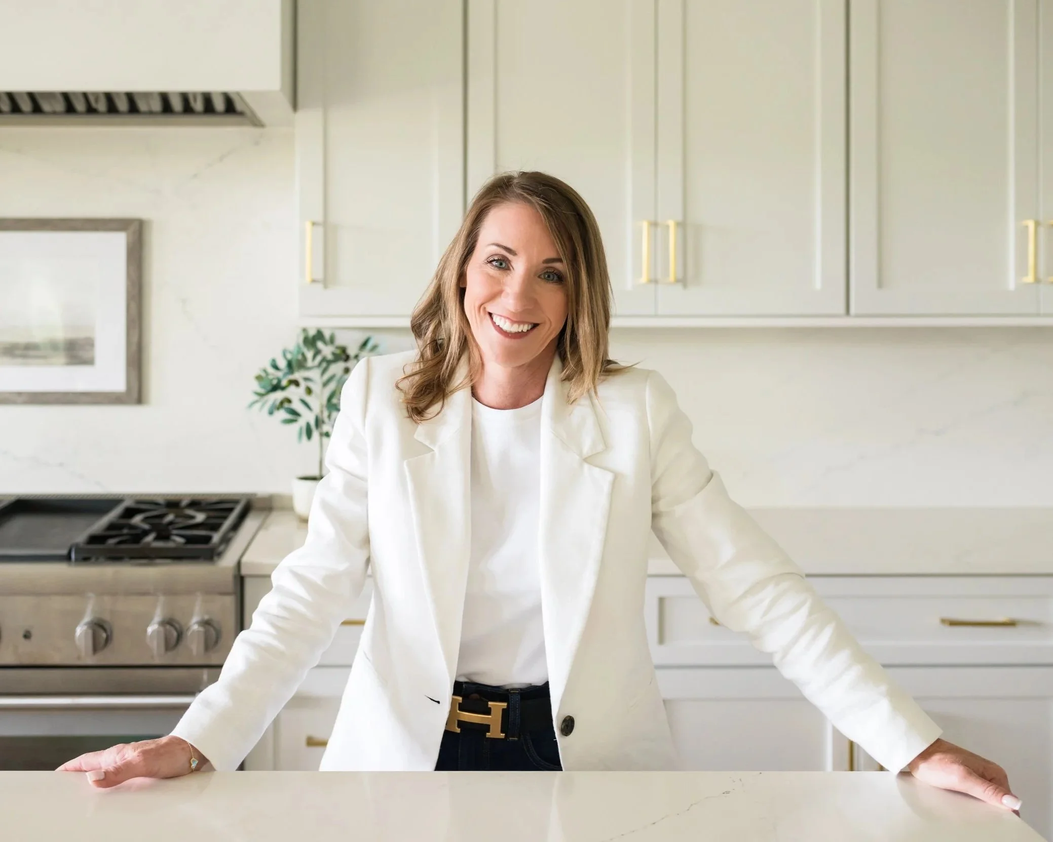 Tiffany Griffin, Franklin TN relocation Realtor with Real Brokerage, in a white blazer in a Franklin, Tennessee home kitchen