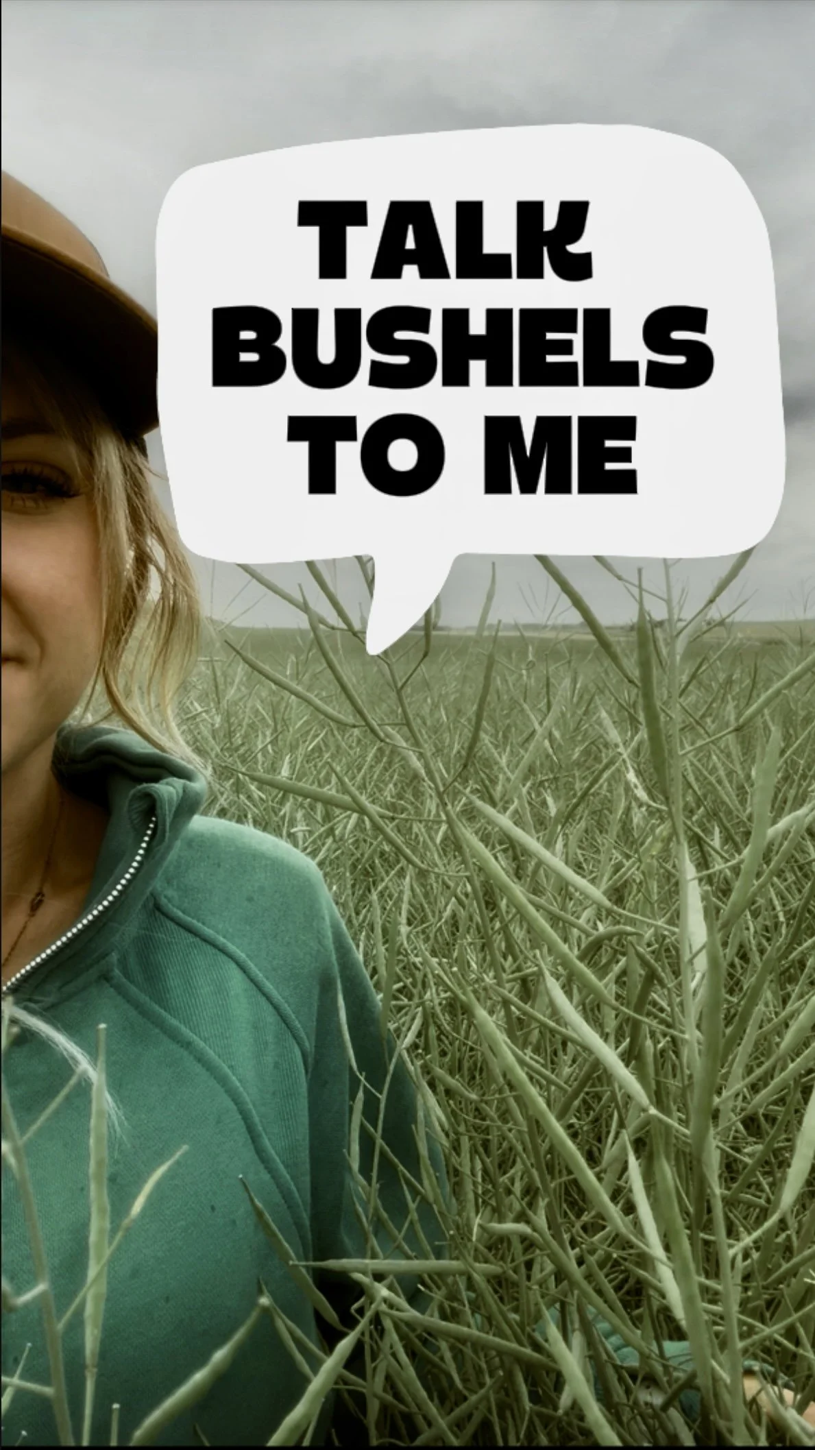 A person standing in a field of leafless bushes, wearing a teal hoodie and a wide-brimmed hat, with a speech bubble text overlay that reads 'TALK BUSHELS TO ME'.