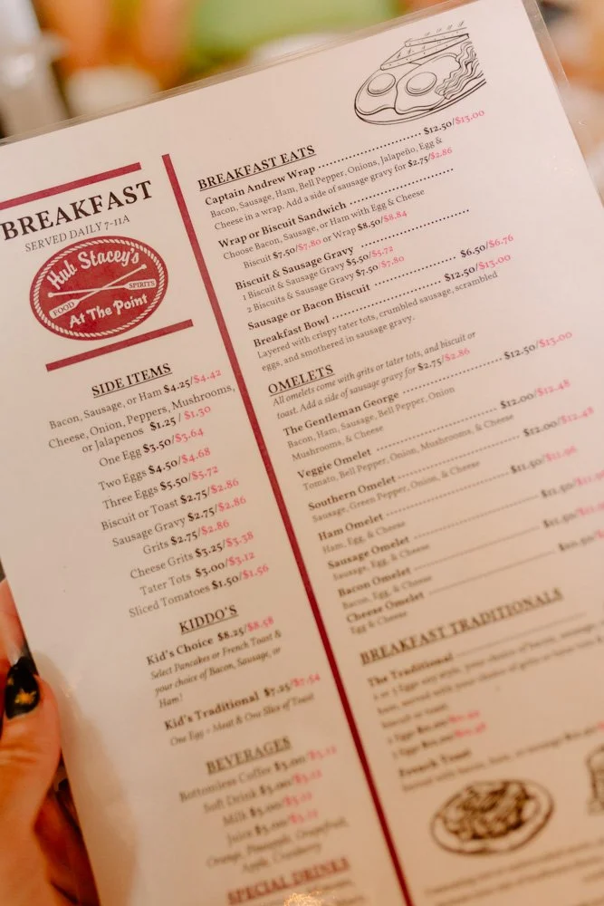 Close-up of a breakfast menu from Hull Stacys, featuring section titles like 'Breakfast Eats,' 'Side Items,' and 'Omelettes,' with food descriptions and prices.