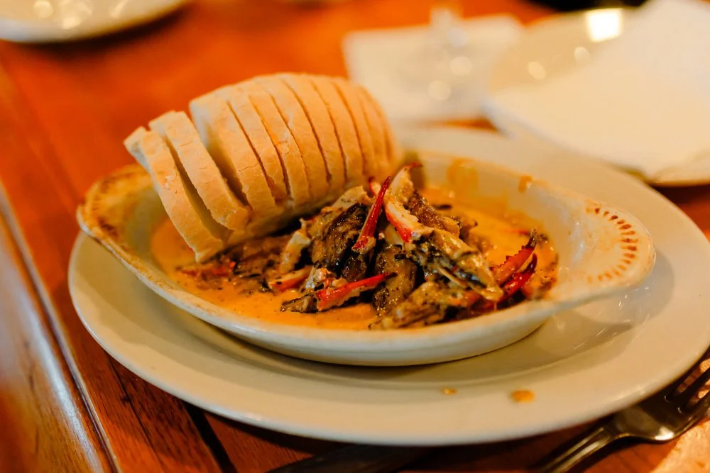 Seafood dish with bread on a white plate at a restaurant.