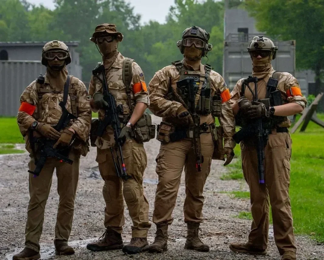 Four Tempest Members at an airsoft field, dressed in matching tan DPM camouflage