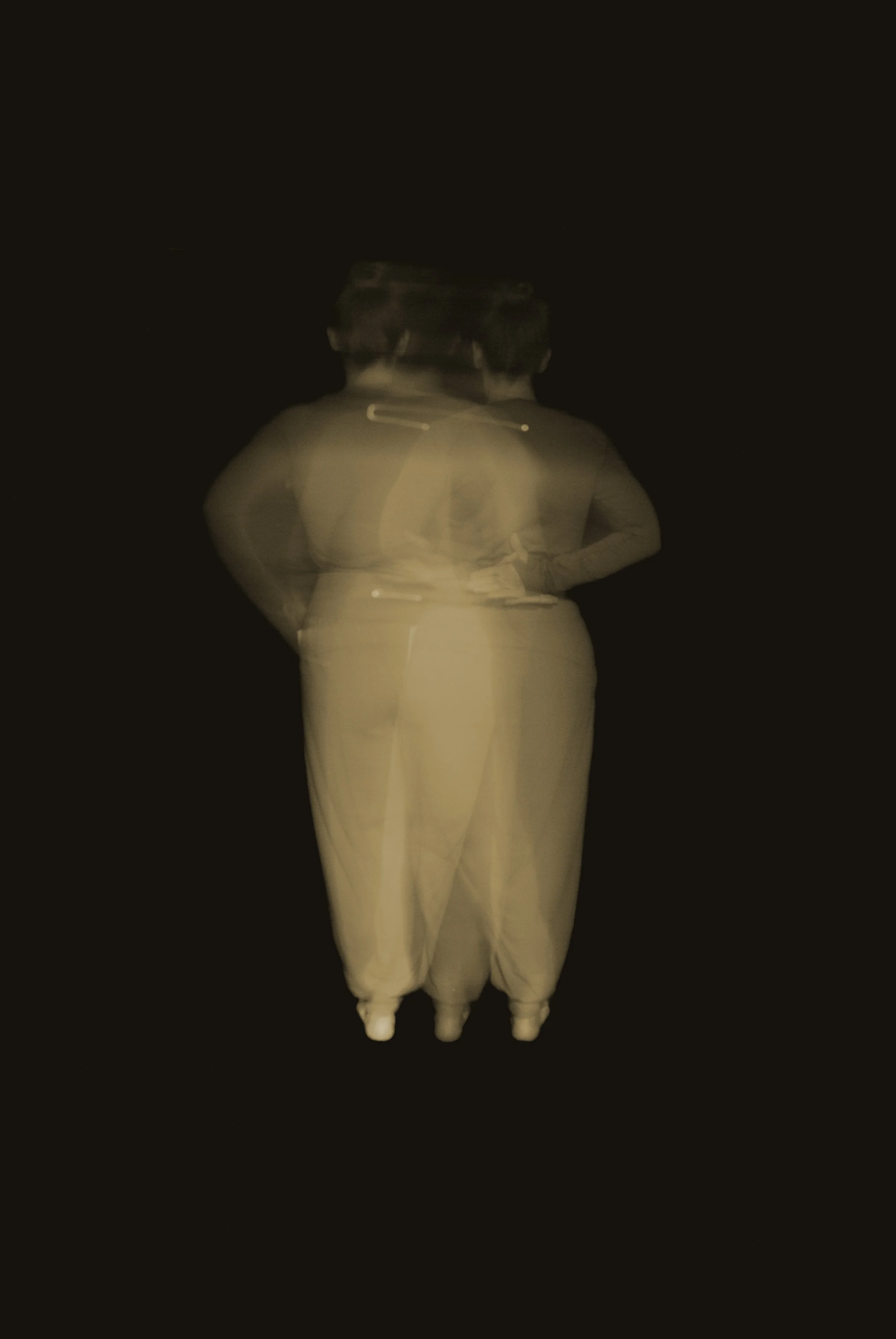 long exposure of body moving into 'at ease' posture' in neutral palette with black background